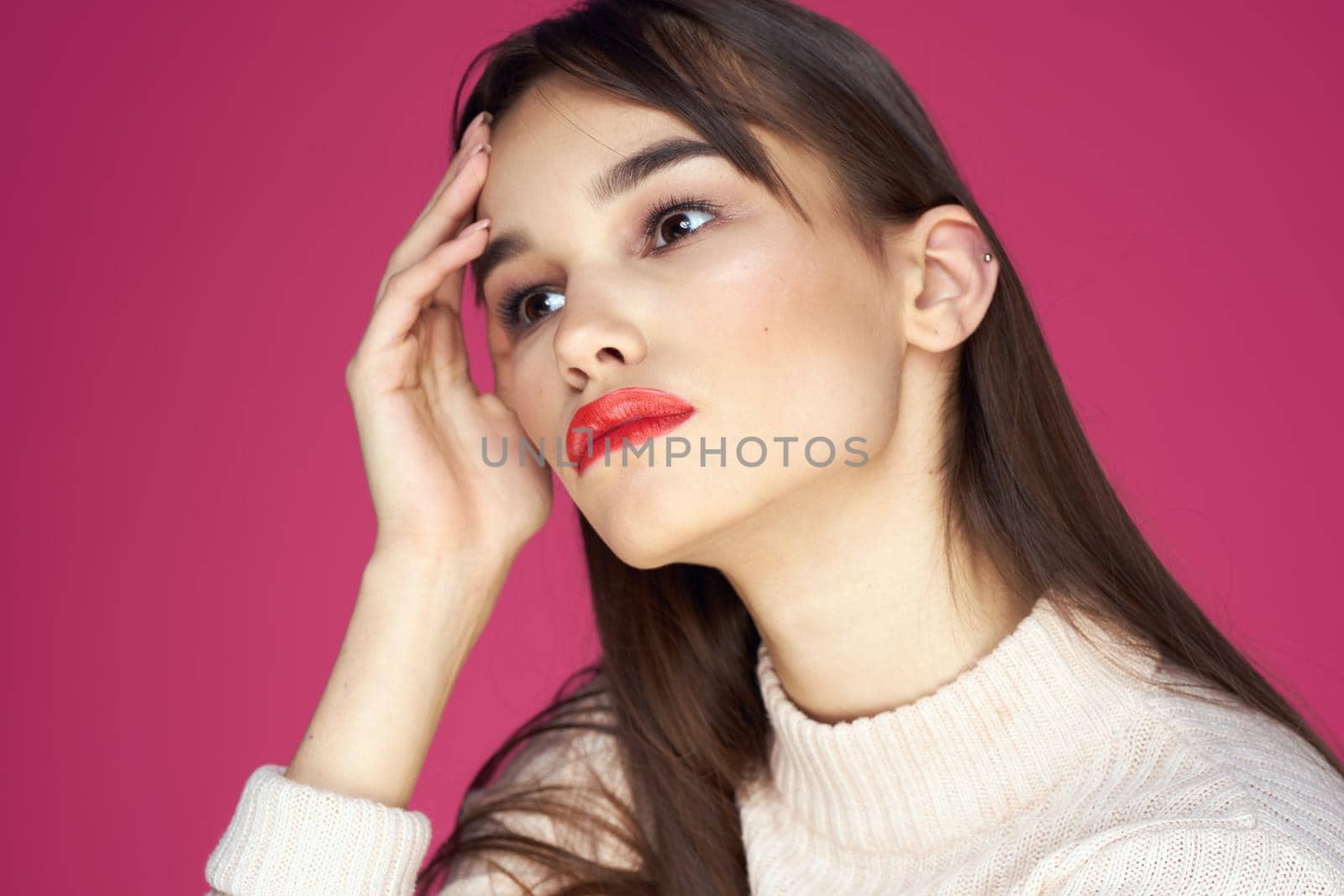 Woman with long hair and red lips white blouse pink background attractive look. High quality photo
