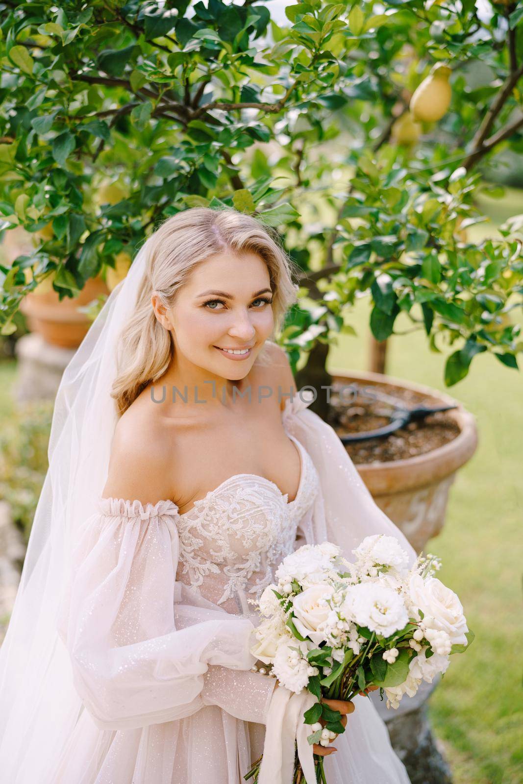 Wedding in Florence, Italy, in an old villa-winery. Bride with a bouquet in the garden, near the lemon tree.