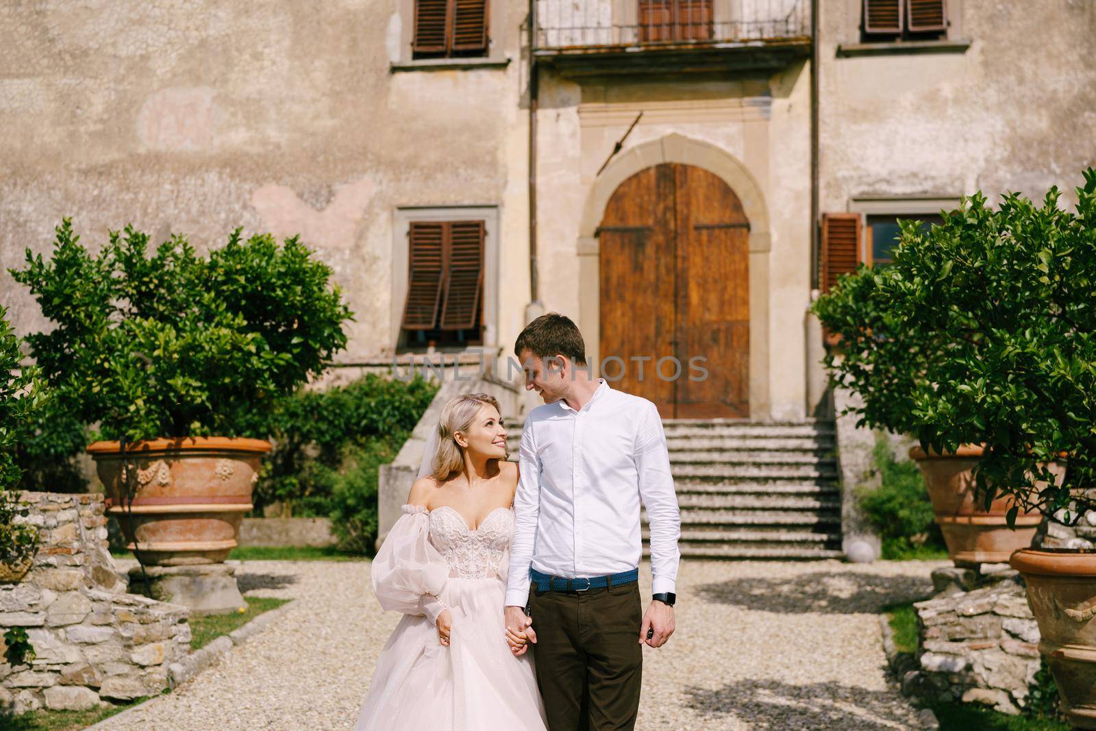 The wedding couple walks in the garden. Lovers of the bride and groom. Wedding in Florence, Italy, in an old villa-winery.