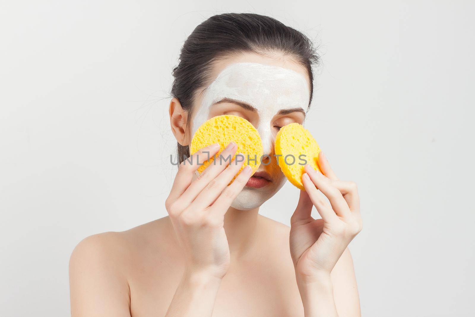 brunette with face mask naked shoulders skincare. High quality photo
