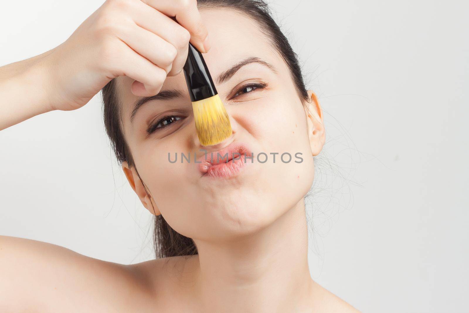 attractive brunette cream mask on face brush for applying cropped look. High quality photo