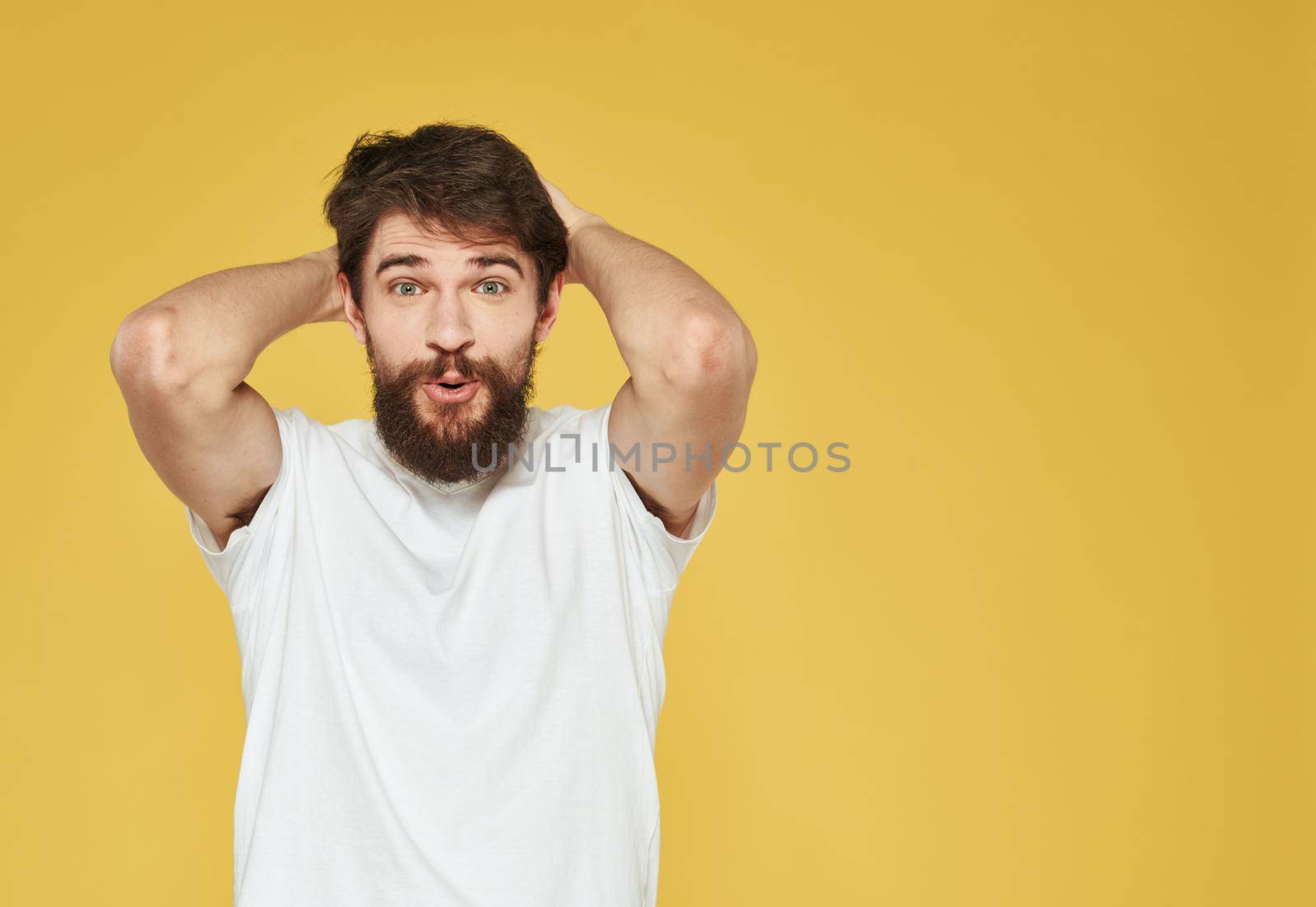 Portrait of a man on a yellow background gesturing with his hands emotions yellow background Copy Space. High quality photo