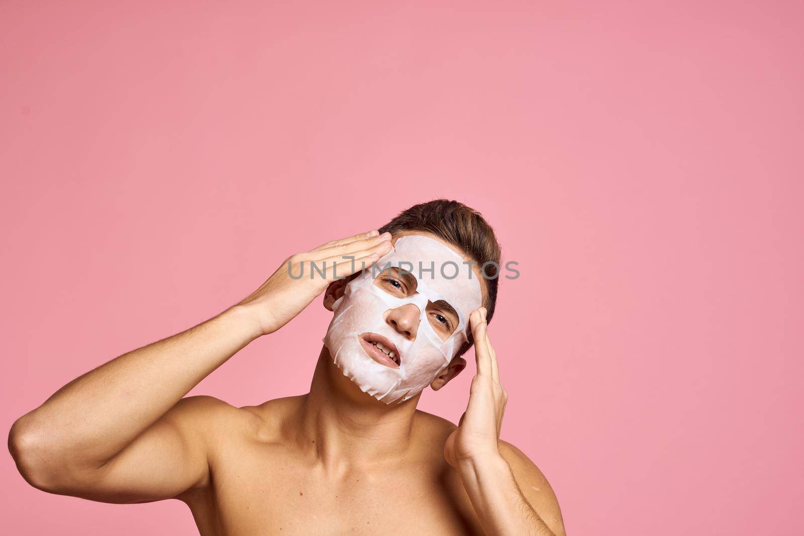 Cute man naked shoulders skin care hygiene pink background. High quality photo