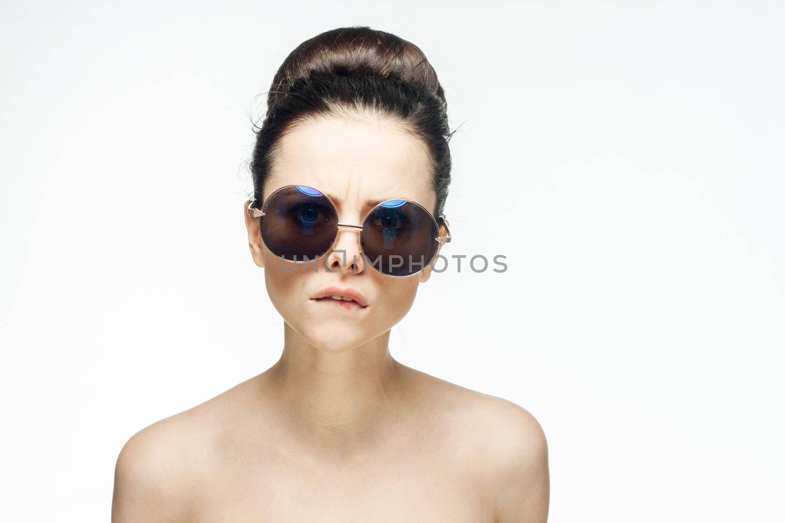 pretty woman naked shoulders sunglasses glamor light background. High quality photo