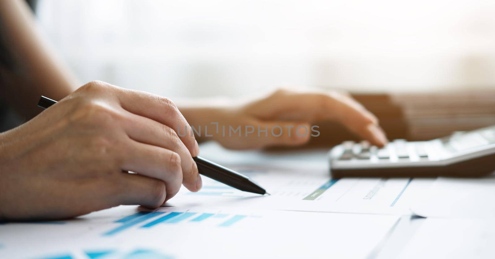 Close up accountant banker or bookkeeper making calculations on financial document. Savings, finances and economy concept.