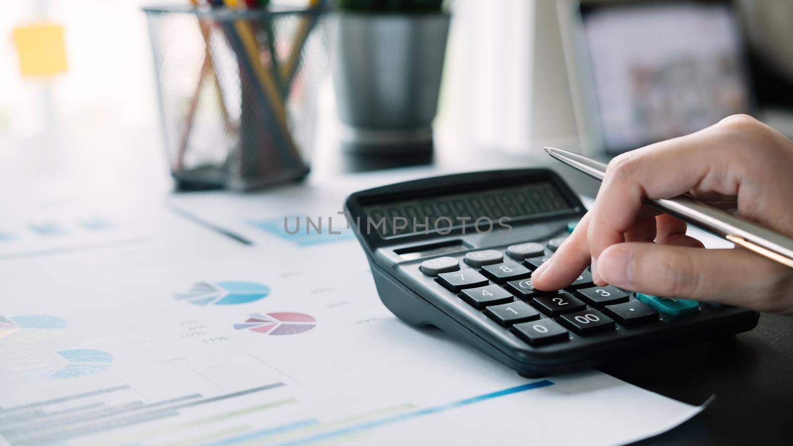 Close up Business or accountant using calculator calculating finance, tax, accounting, statistics and analytic research concept