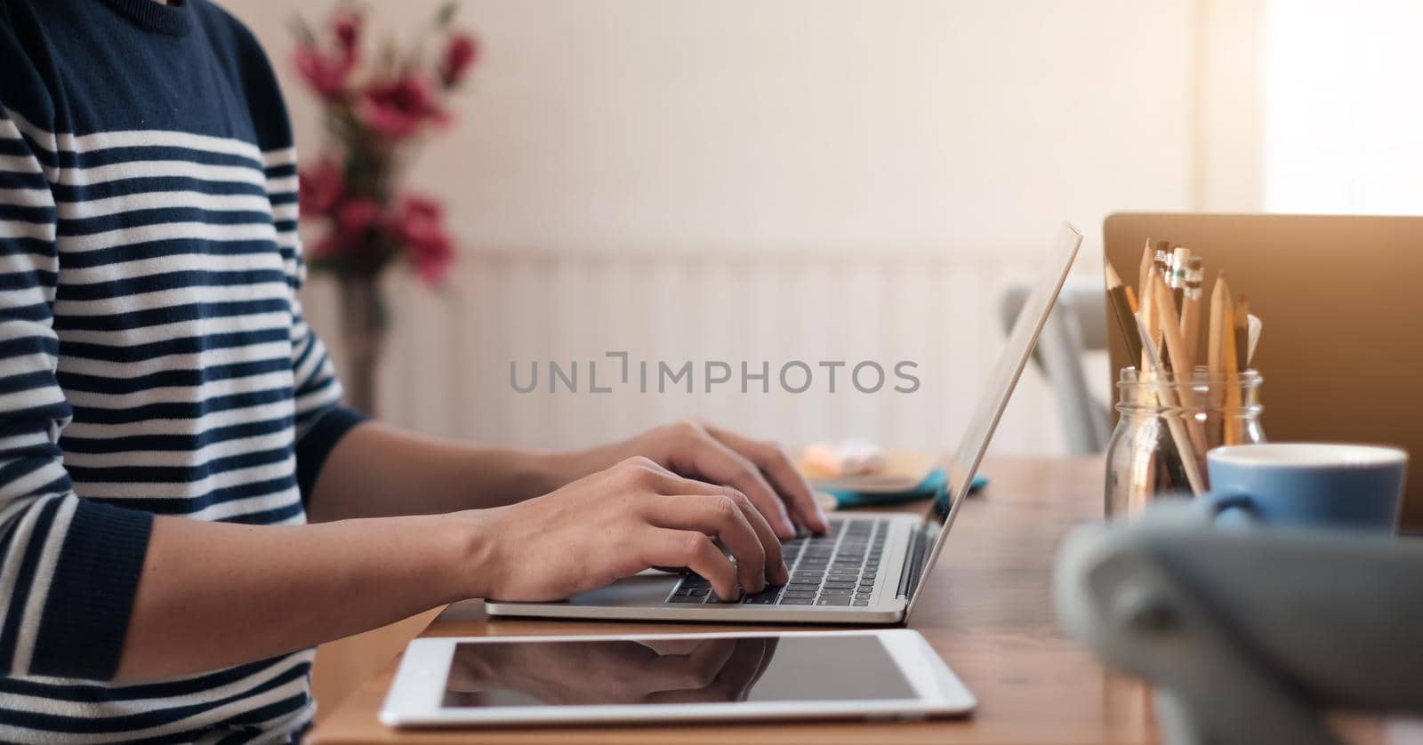 Close up young casual man sitting at desk studying on laptop happy at the coffee shop by nateemee