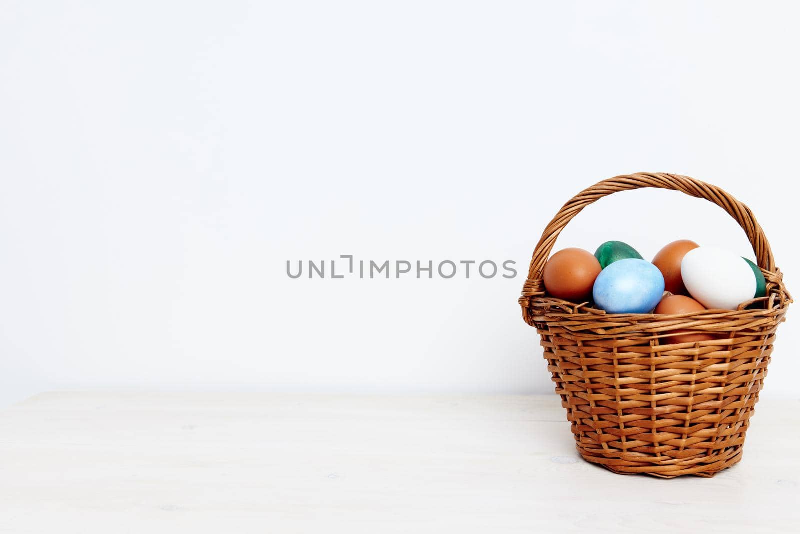 Easter eggs in a wicker basket on a Light background Copy Space. High quality photo