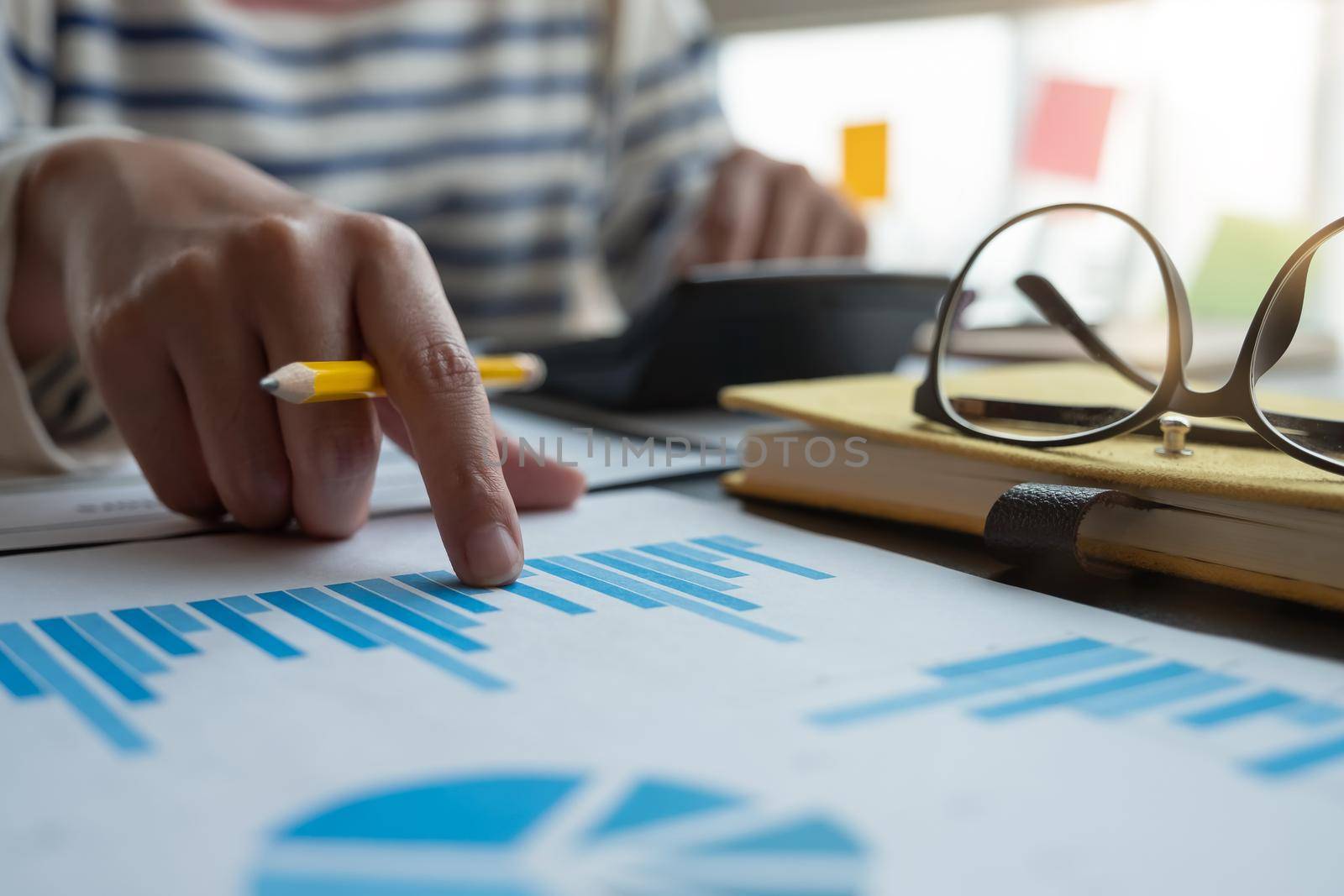 Close up hand of accountant or banker working on calculator to calculate financial data report, accountancy document, business work at home concept