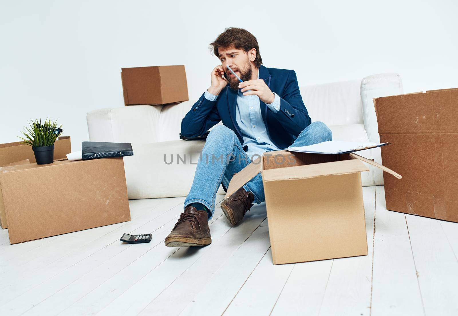 Business man near boxes with things unpacking moving to a new location office . High quality photo