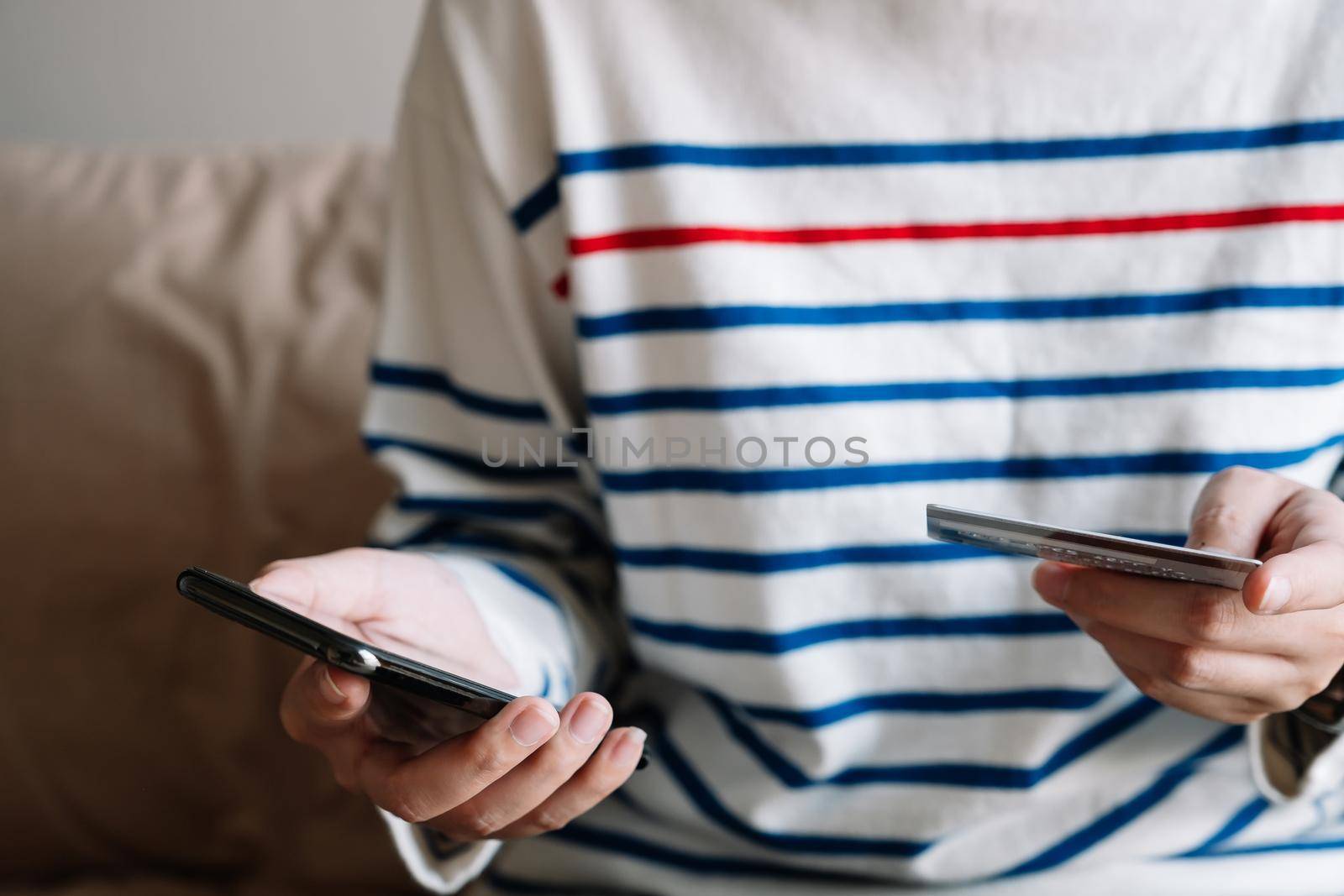 Online shopping payment,Woman's hands holding a smart phone and credit card and for online shopping at home