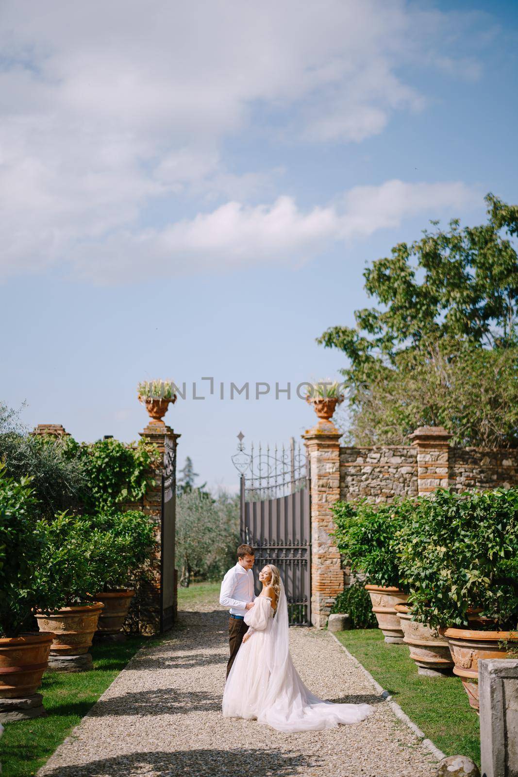 The wedding couple walks in the garden. Lovers of the bride and groom. Wedding in Florence, Italy, in an old villa-winery.