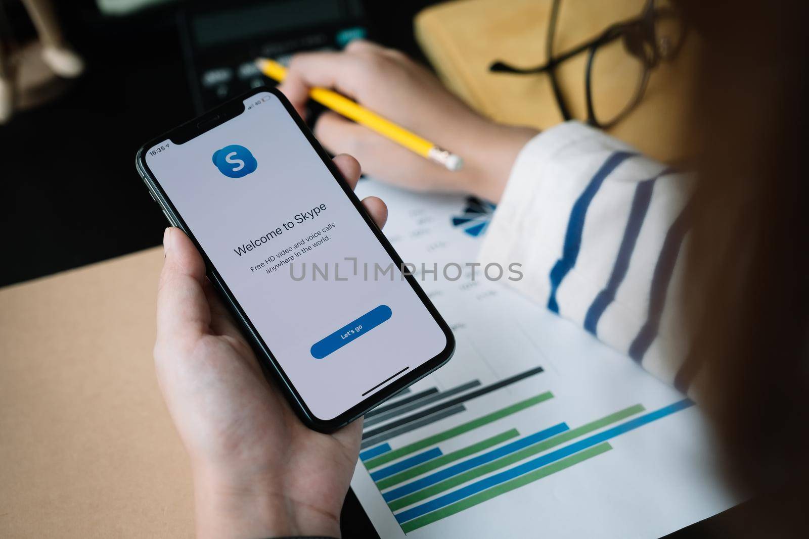 CHIANG MAI,THAILAND - APR 06, 2020 : Woman holding iphone Xs with Skype application, Skype is part of Microsoft, can make video, audio calls, chat messages and do much more using Skype.