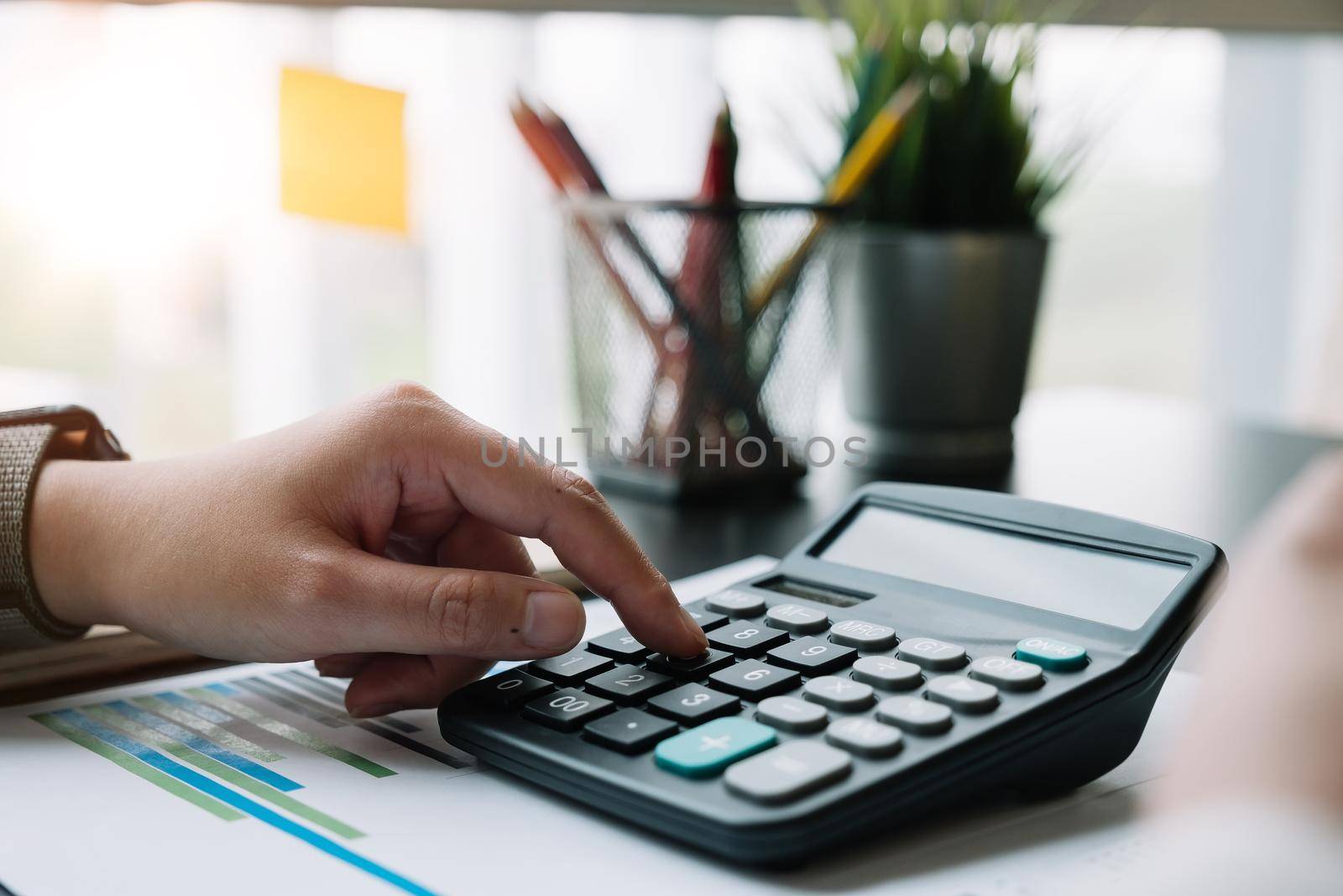 Close up hand of accountant or banker working on calculator to calculate financial data report, accountancy document, business work at home concept