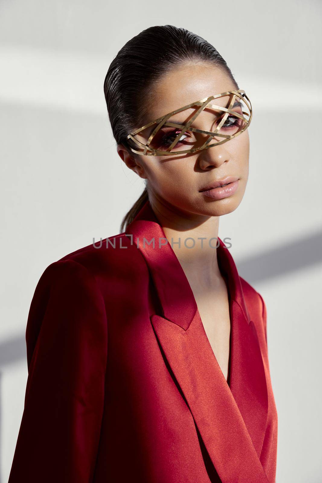 portrait of a stylish woman in a red jacket and jewelry on her face iron glasses new technology. High quality photo