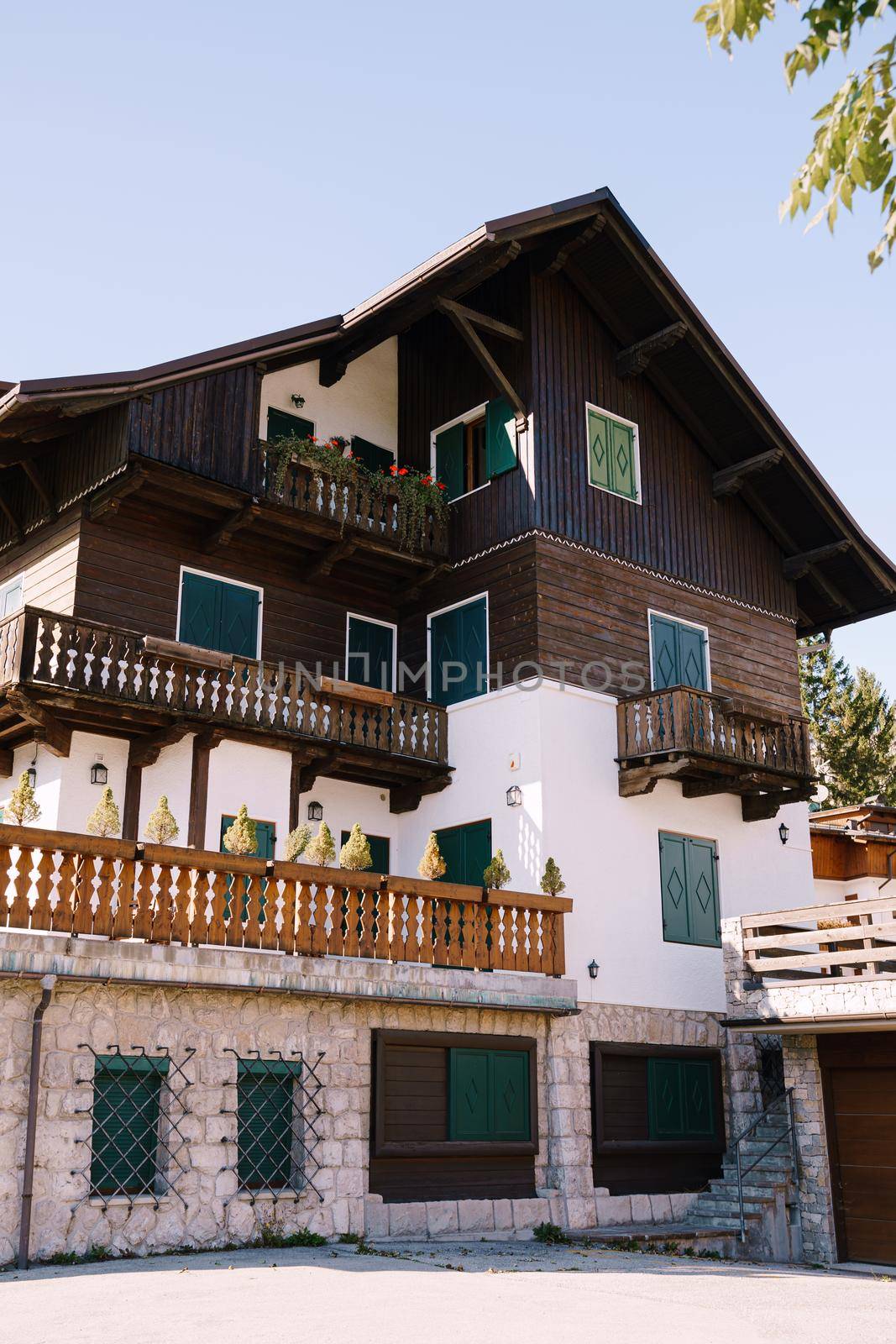 White whitewashed house, with wooden elements in northern Italy, in the Dolomites area, in a winter ski resort, in the city of Cortina Ampezzo.