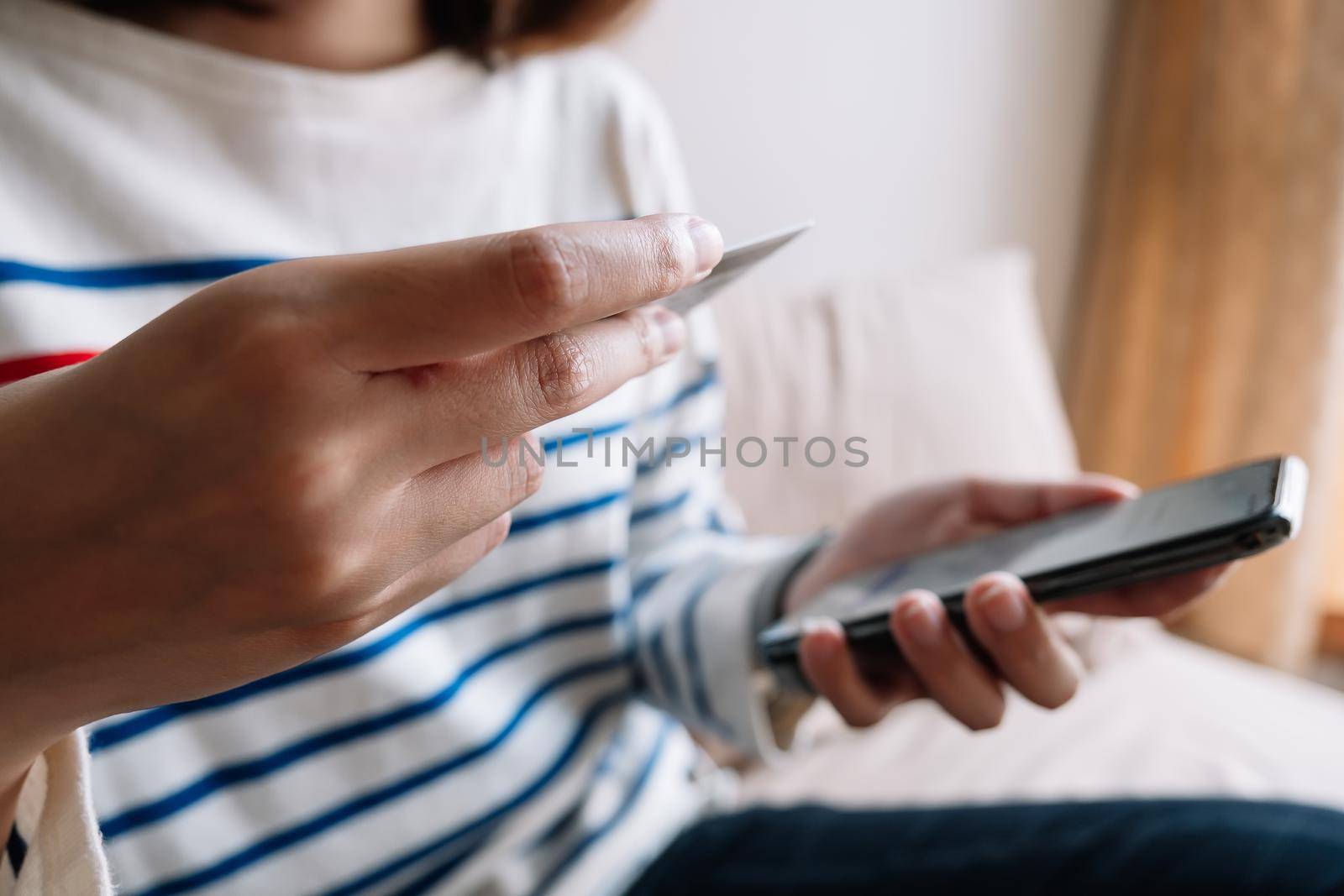 Online shopping payment,Woman's hands holding a smart phone and credit card and for online shopping at home