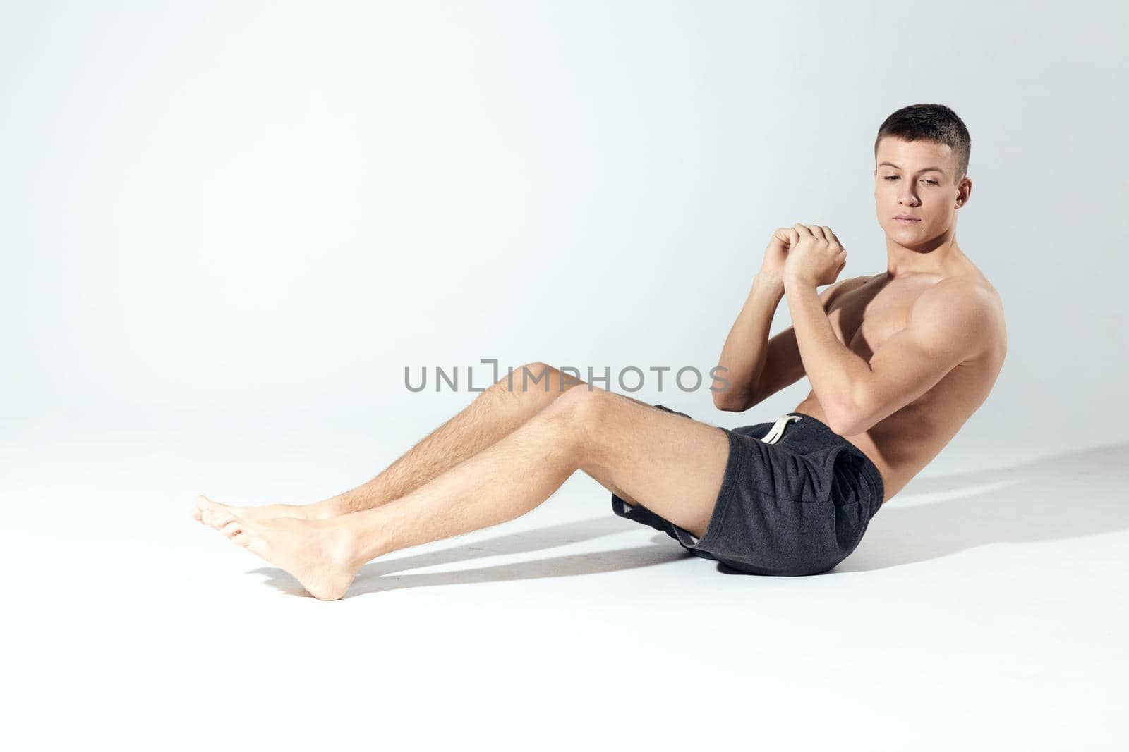 a man shakes the press In a bright room sitting on the floor in full growth on a light background. High quality photo