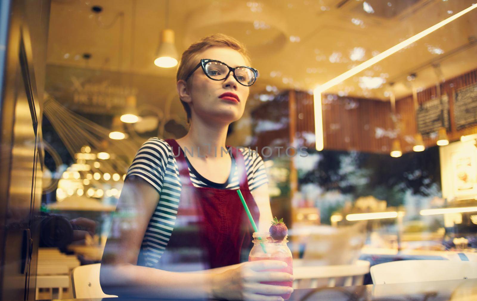 fashionable woman in red sundress resting in a cafe with a drink by SHOTPRIME