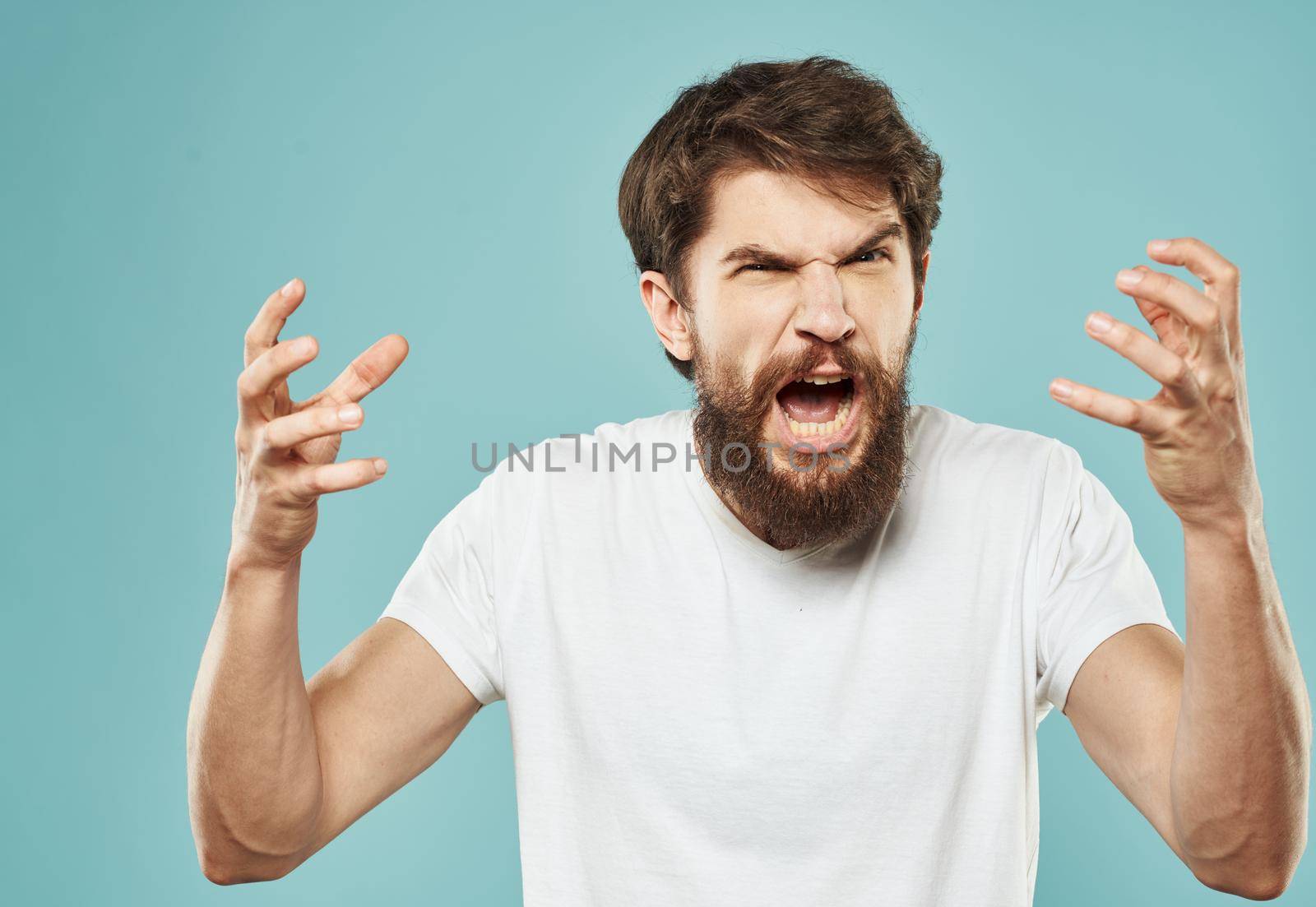 emotional man with beard on blue background gesturing with hands cropped view Copy Space by SHOTPRIME