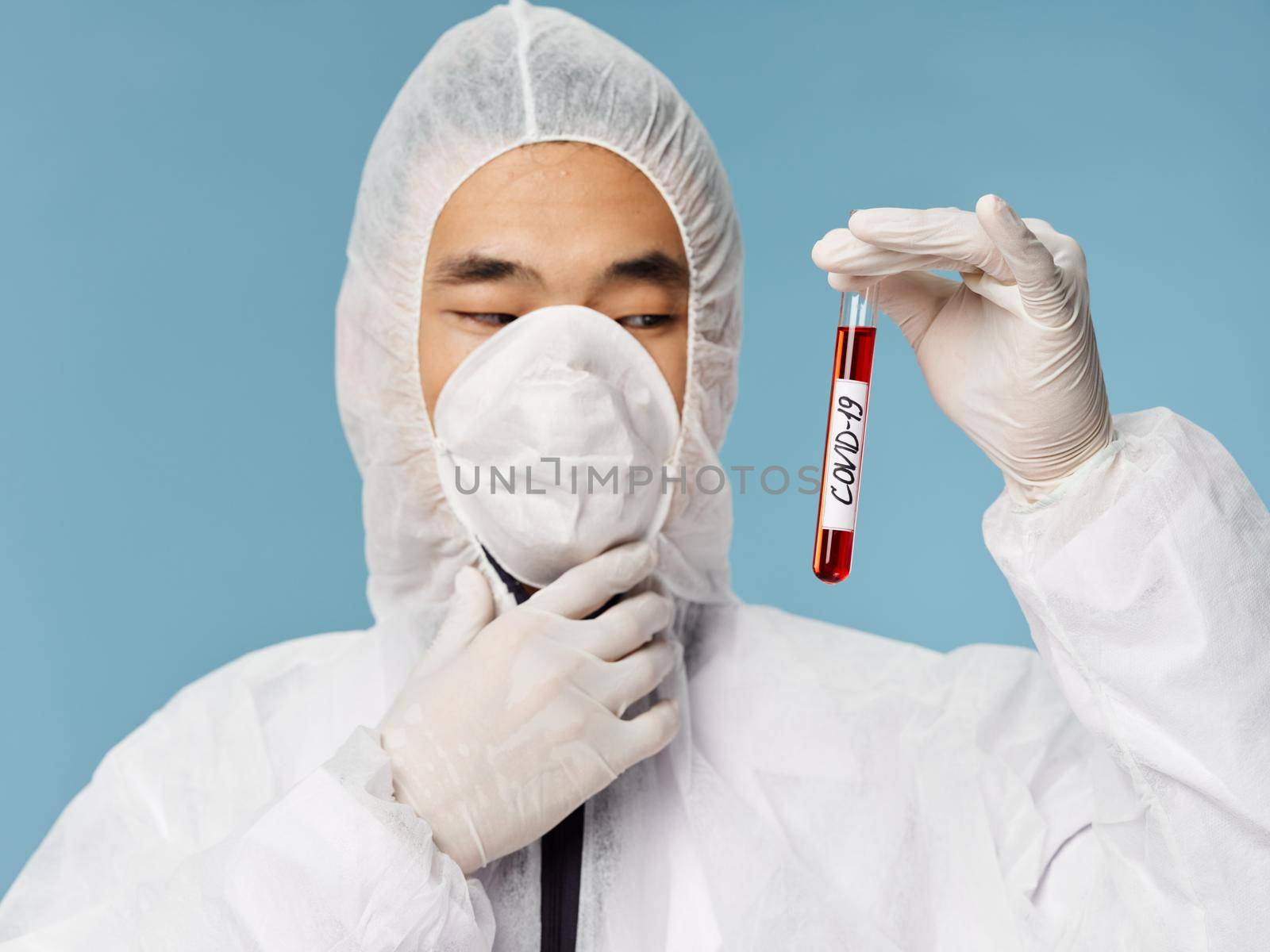 Male laboratory assistant blood test covid-19 research biotechnology blue background. High quality photo