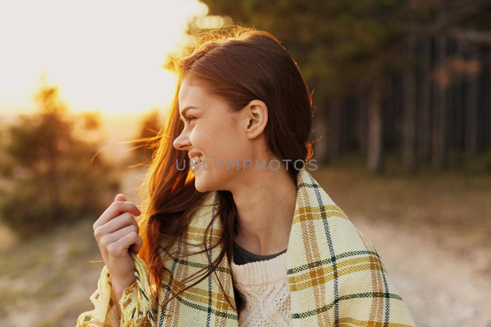 Happy hiker woman trail on shoulders at sunset near the forest. High quality photo