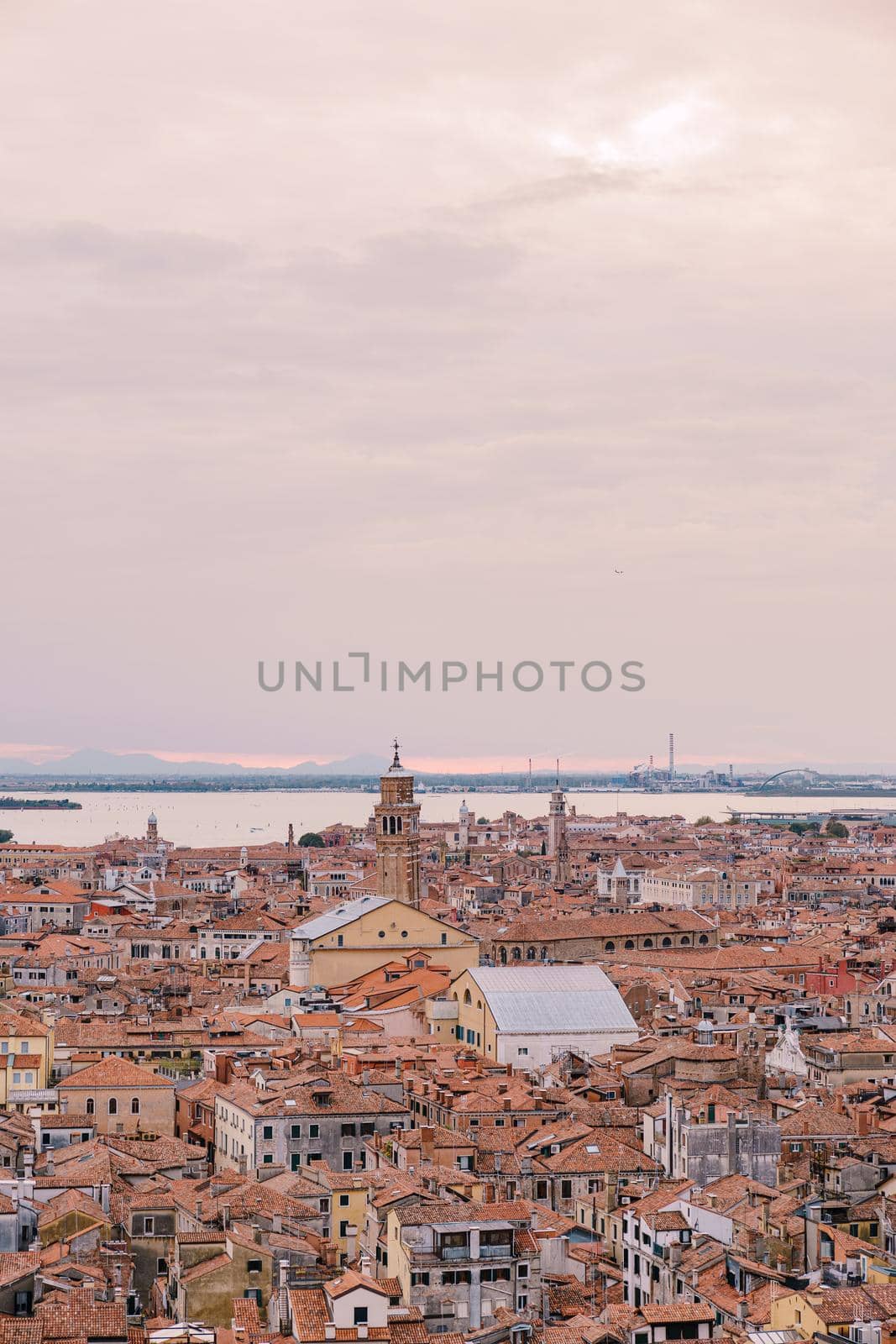 Aerial panoramic view from cathedral bell tower San Marco Campanile of old historical city centre, sea, red tiled roofs and palaces. Venice is a popular tourist destination of Europe