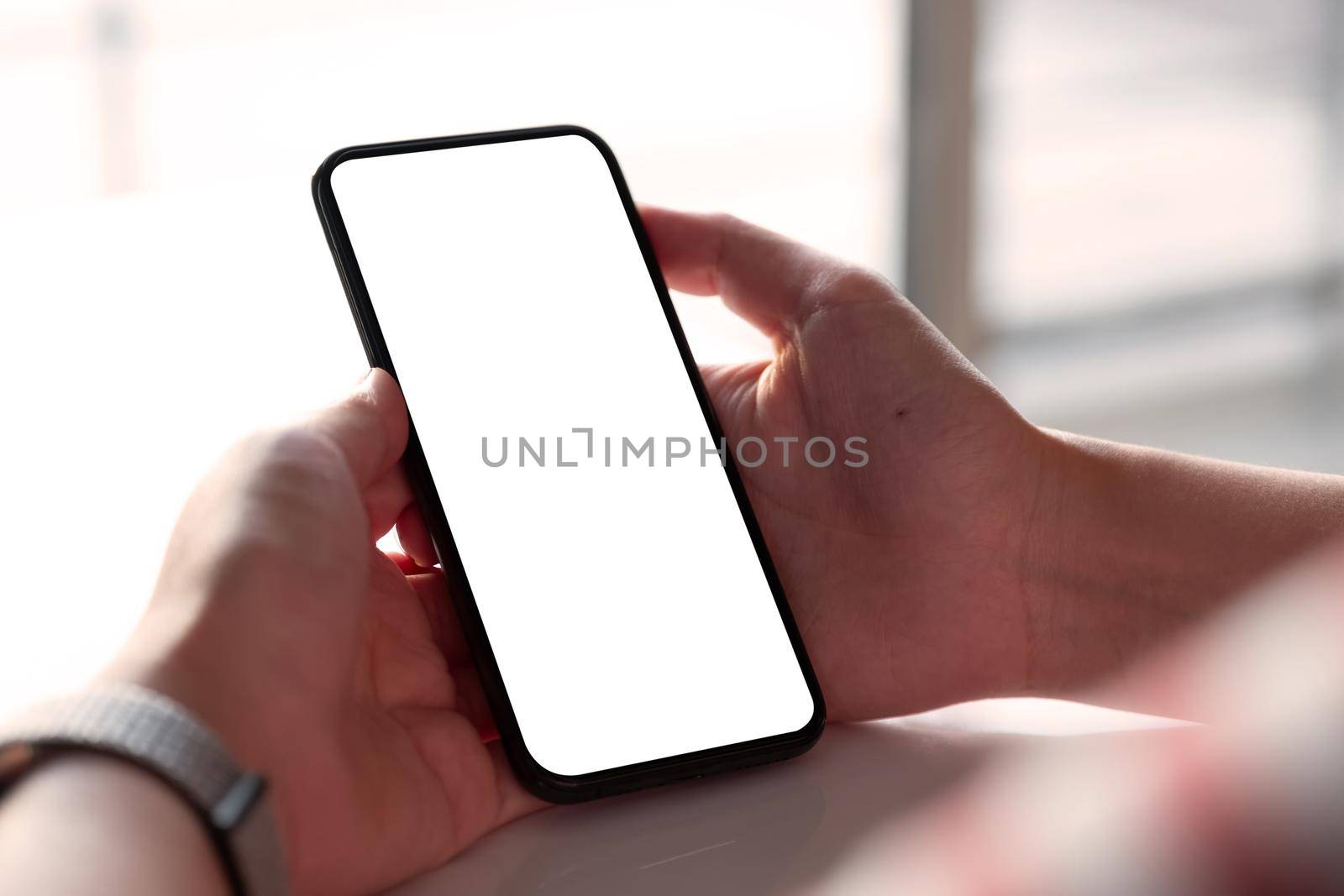 Woman holding blank screen mock up mobile phone.