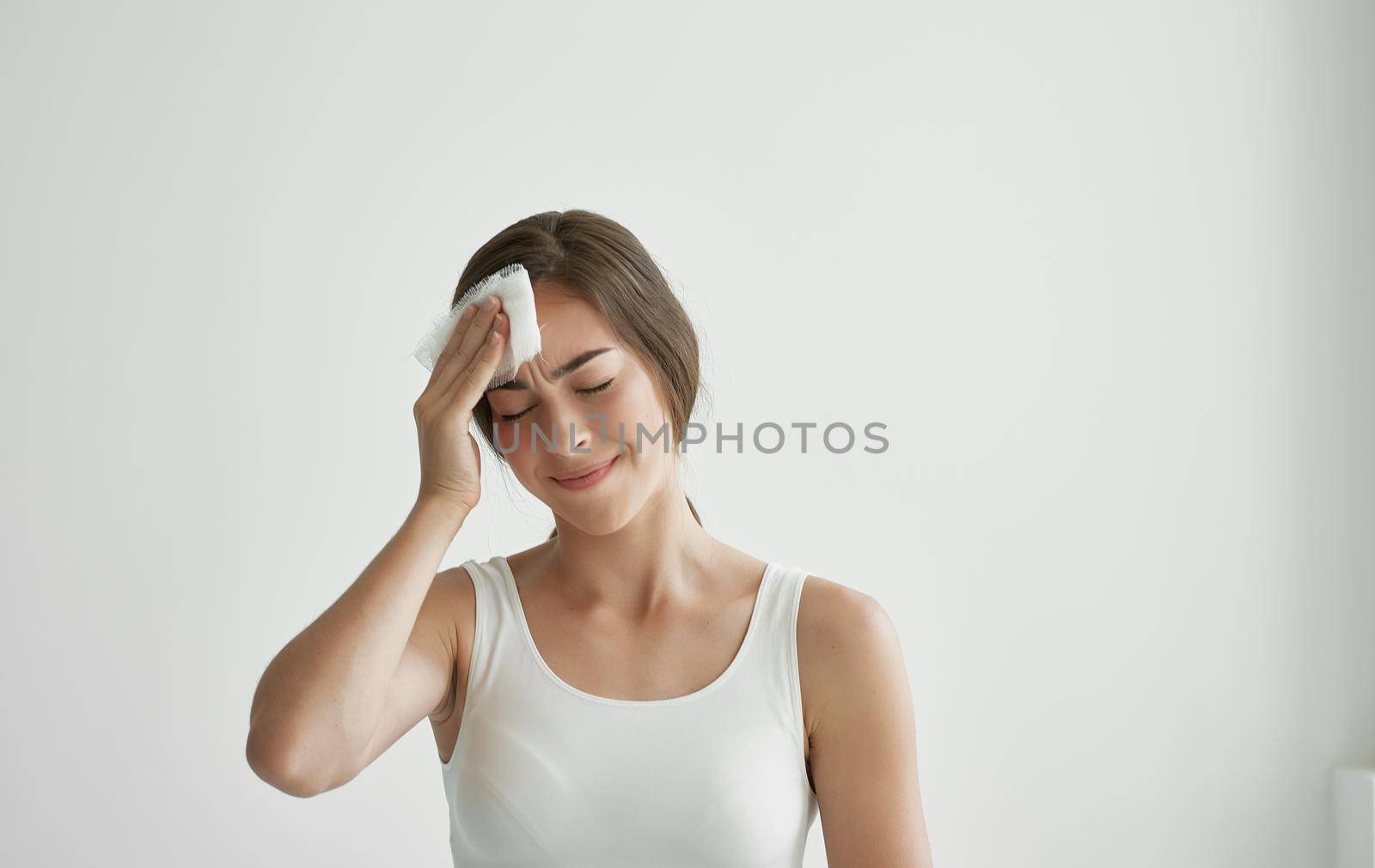 woman with a cold holding her head flu health problems by SHOTPRIME