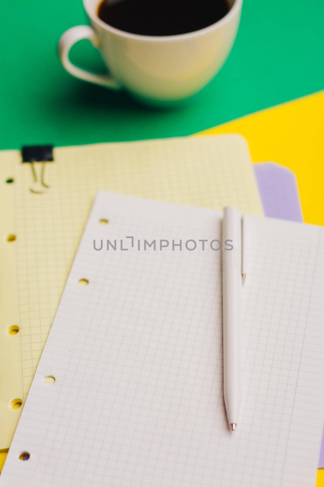 cup of coffee on a colored background and sheets of paper notepad office glasses. High quality photo