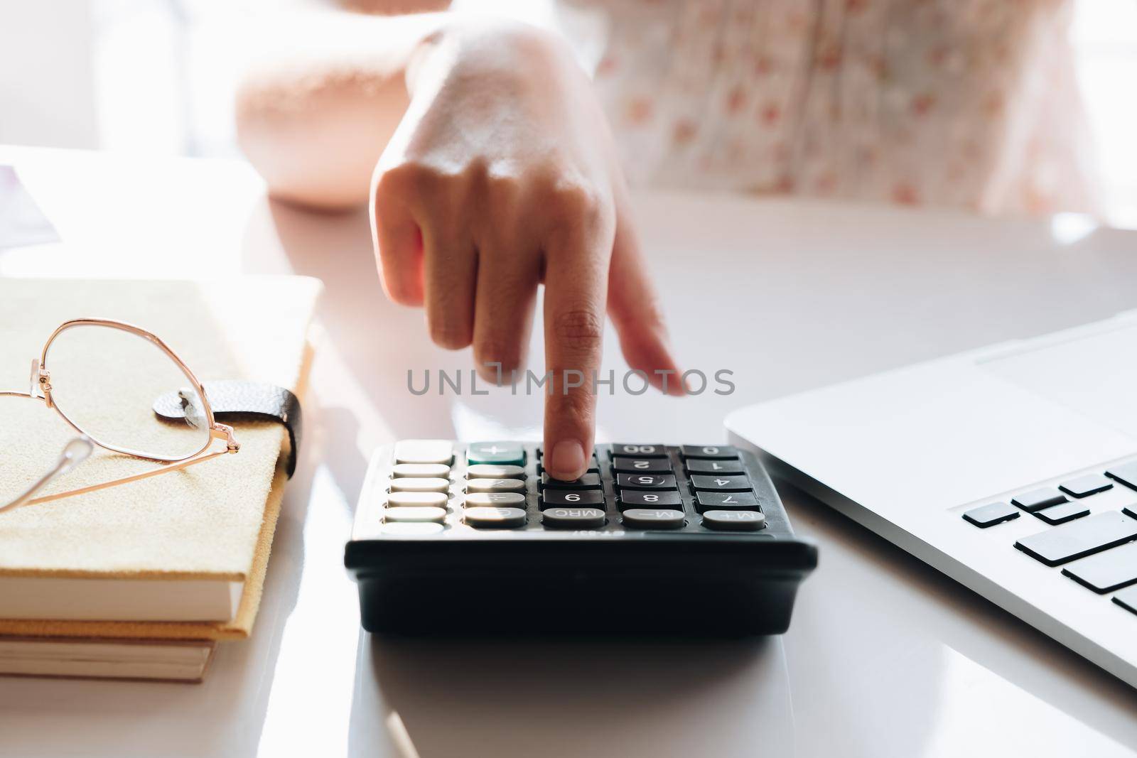 Close up Businesswoman using calculator and laptop for do math finance on wooden desk in office and business working background, tax, accounting, statistics and analytic research concept