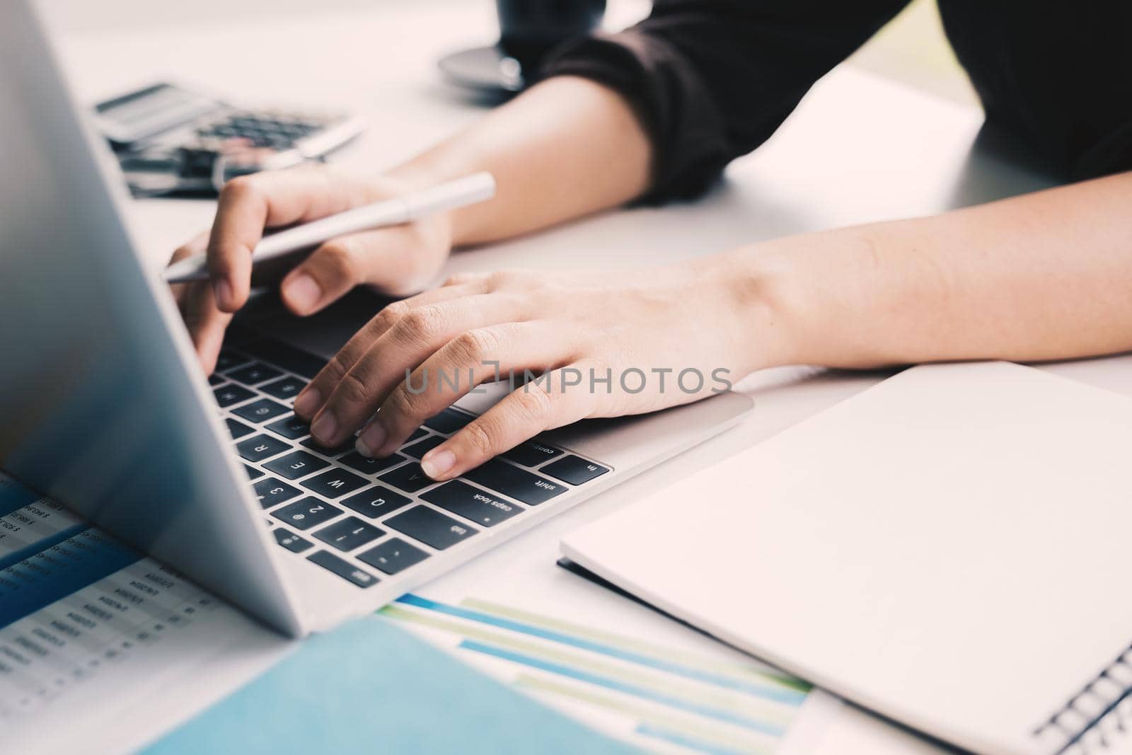Close up hand of business woman using laptop computer for financial analysis.