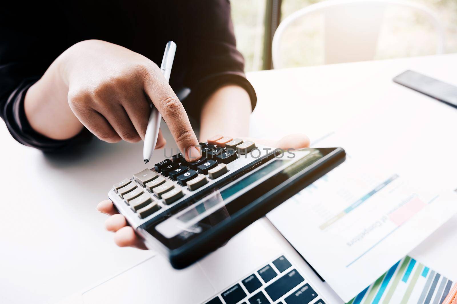 Close up Business woman using calculator for do math finance on wooden desk by nateemee