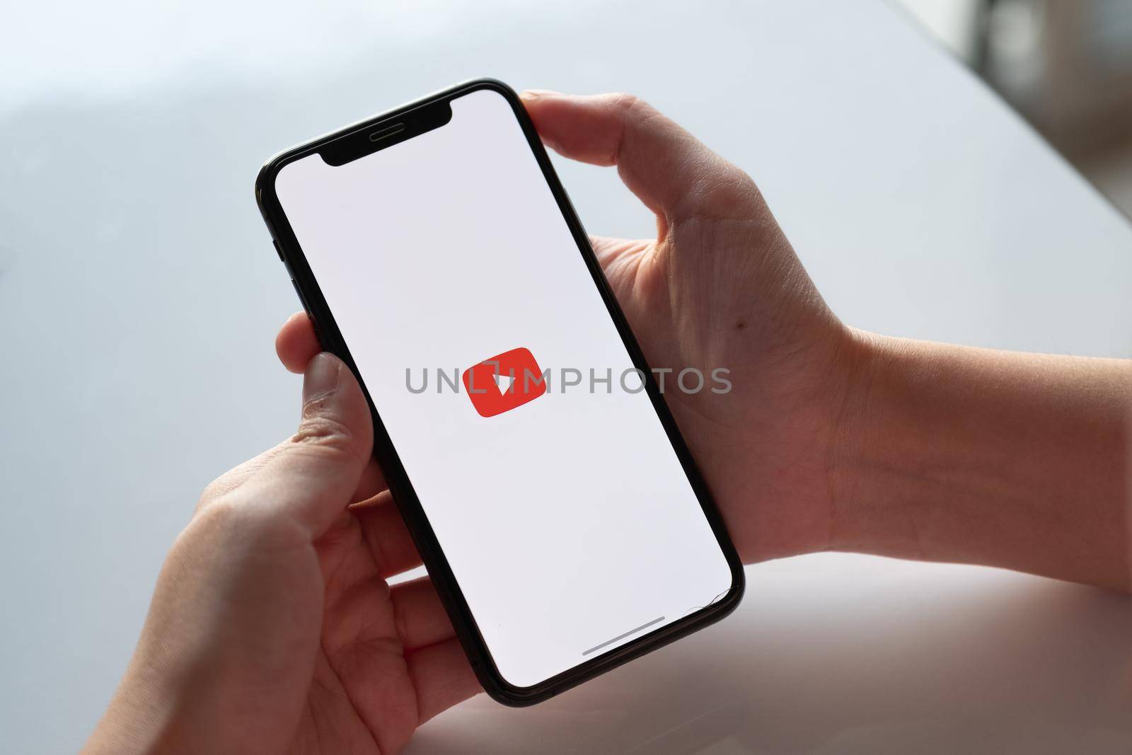 CHIANG MAI, THAILAND - NOV.17 ,2019: Woman holding iPhone Xs with Youtube apps on screen. by nateemee