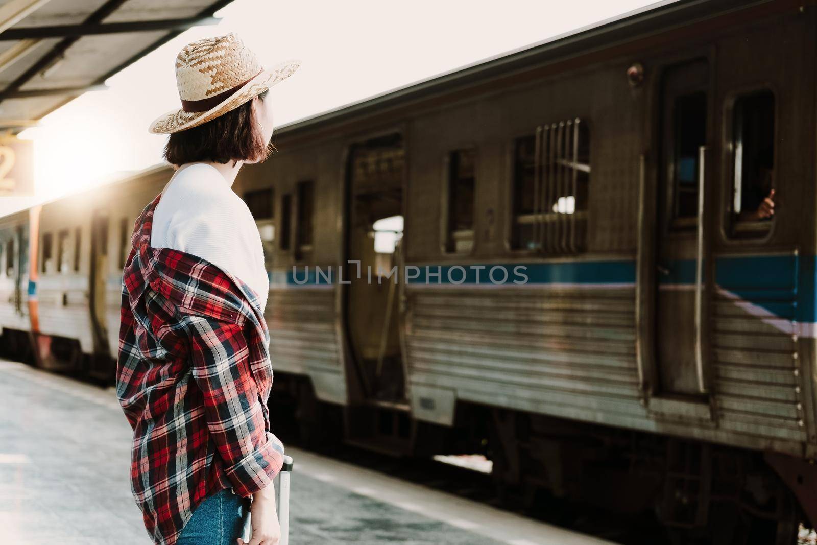 Pretty woman waiting the train at train station for travel in summer. Travel concept.