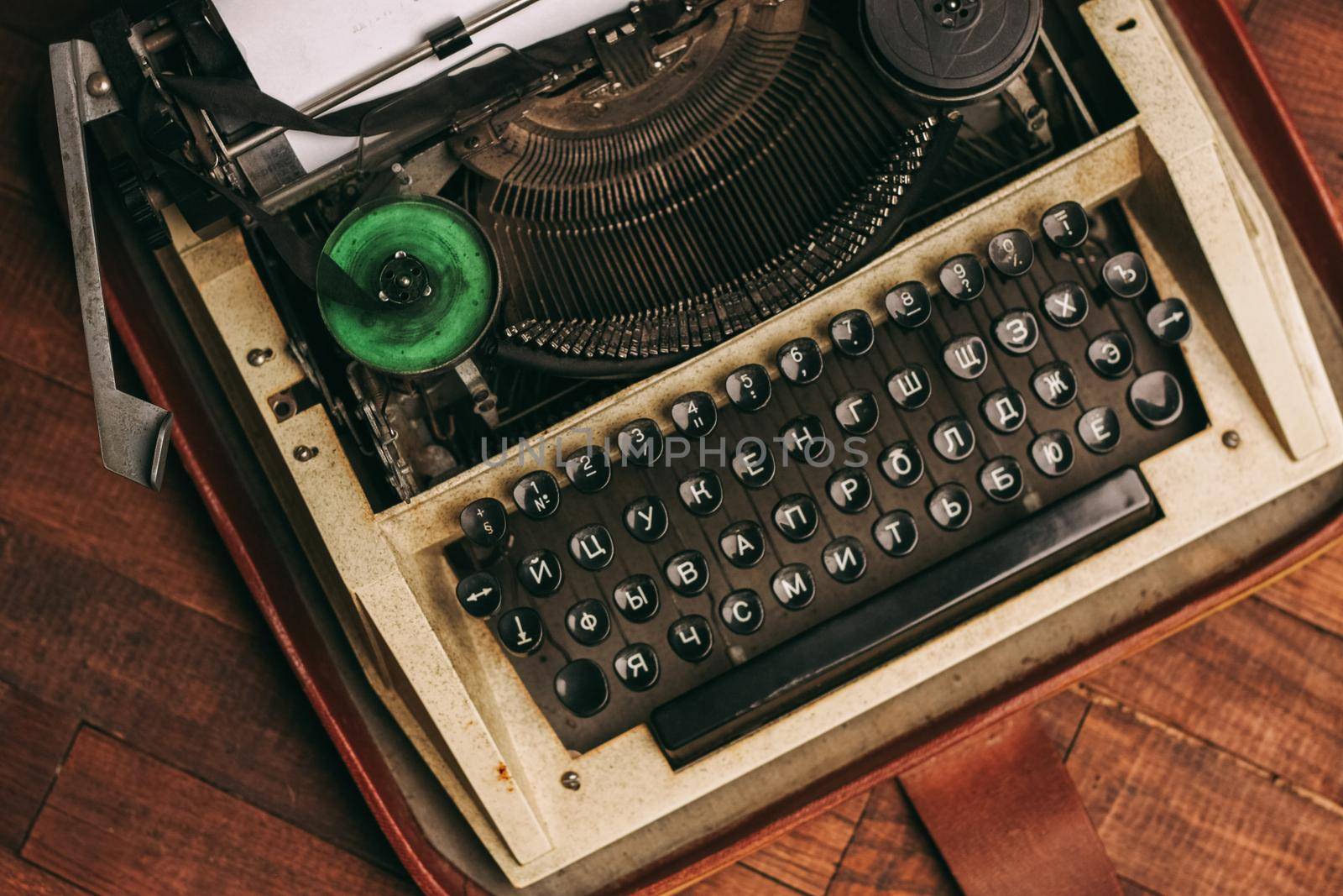 vintage typewriter with keys on a wooden background and a white sheet of paper by SHOTPRIME