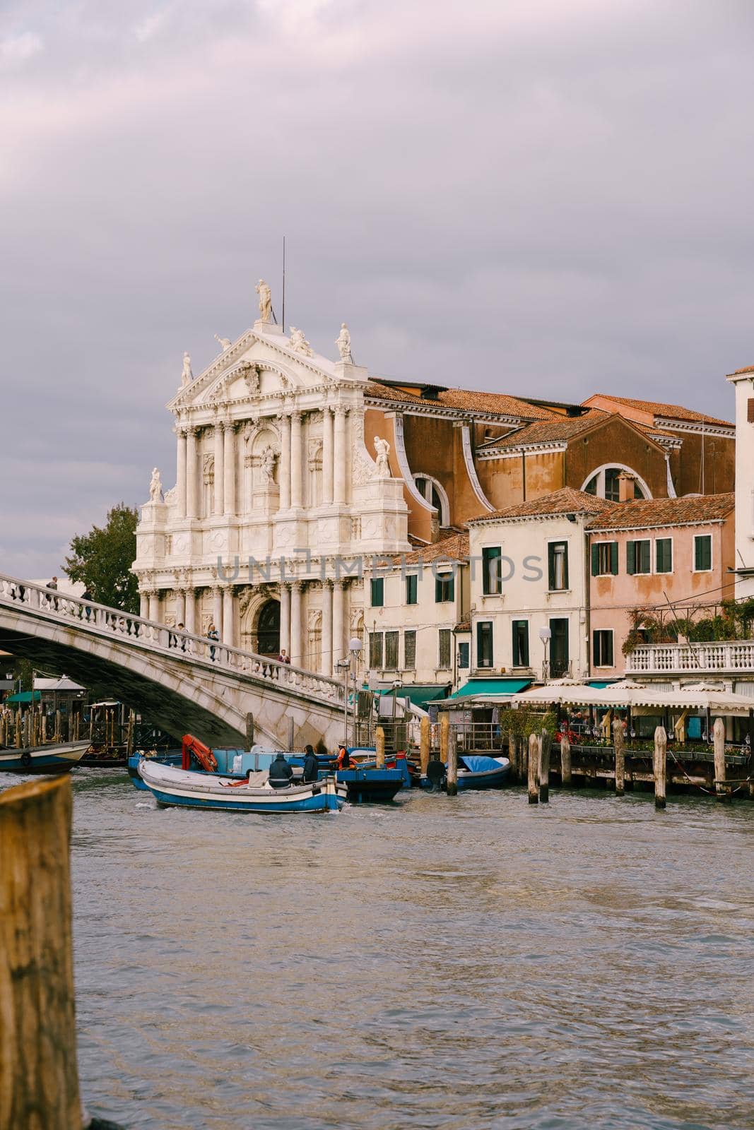 View from the water of the grand canal on the Scalzi Bridge and the Church of Scalzi. A very beautiful building with snow-white columns against blue sky with clouds in Venice, Italy