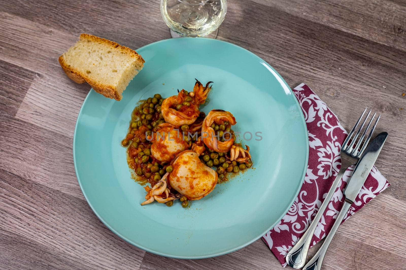 flat composition cuttlefish and peas with glass of wine cutlery and bread