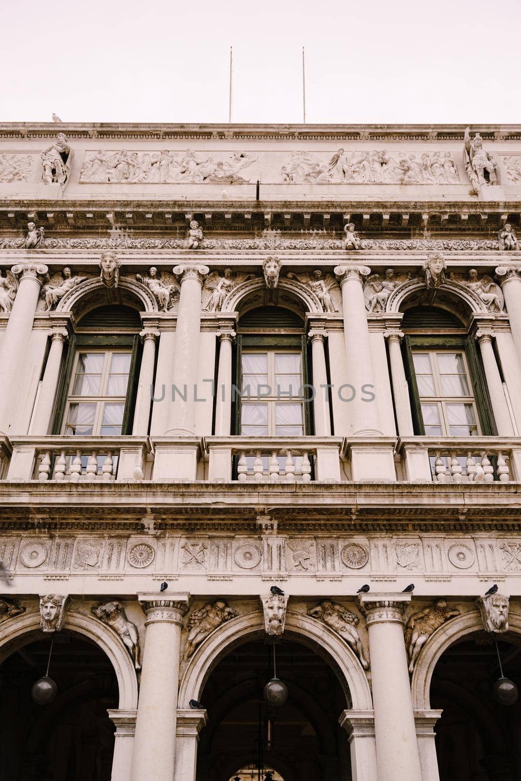 Vintage ornate windows and columns, venetian style, on fragment of building's luxurious building in Venice. Traditional ancient medieval gothic style