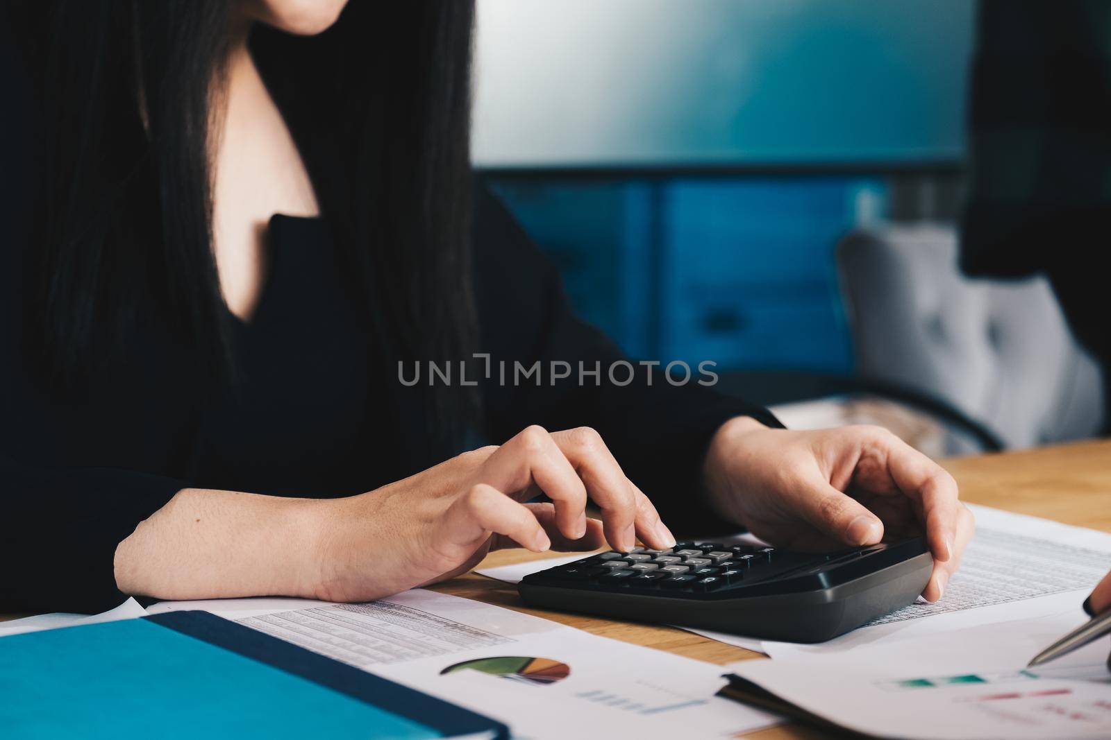 Close up of businessman or accountant hand working on calculator to calculate financial data report, accountancy document and laptop computer at office, business concept