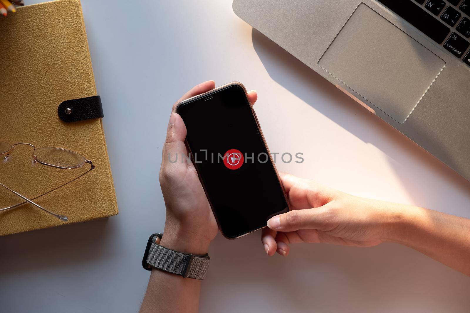 CHIANG MAI, THAILAND - DEC.14 ,2019 : Woman using iPhone Xs with Youtube Music - Stream Songs and Music Videos app on the display of smartphone or tablet