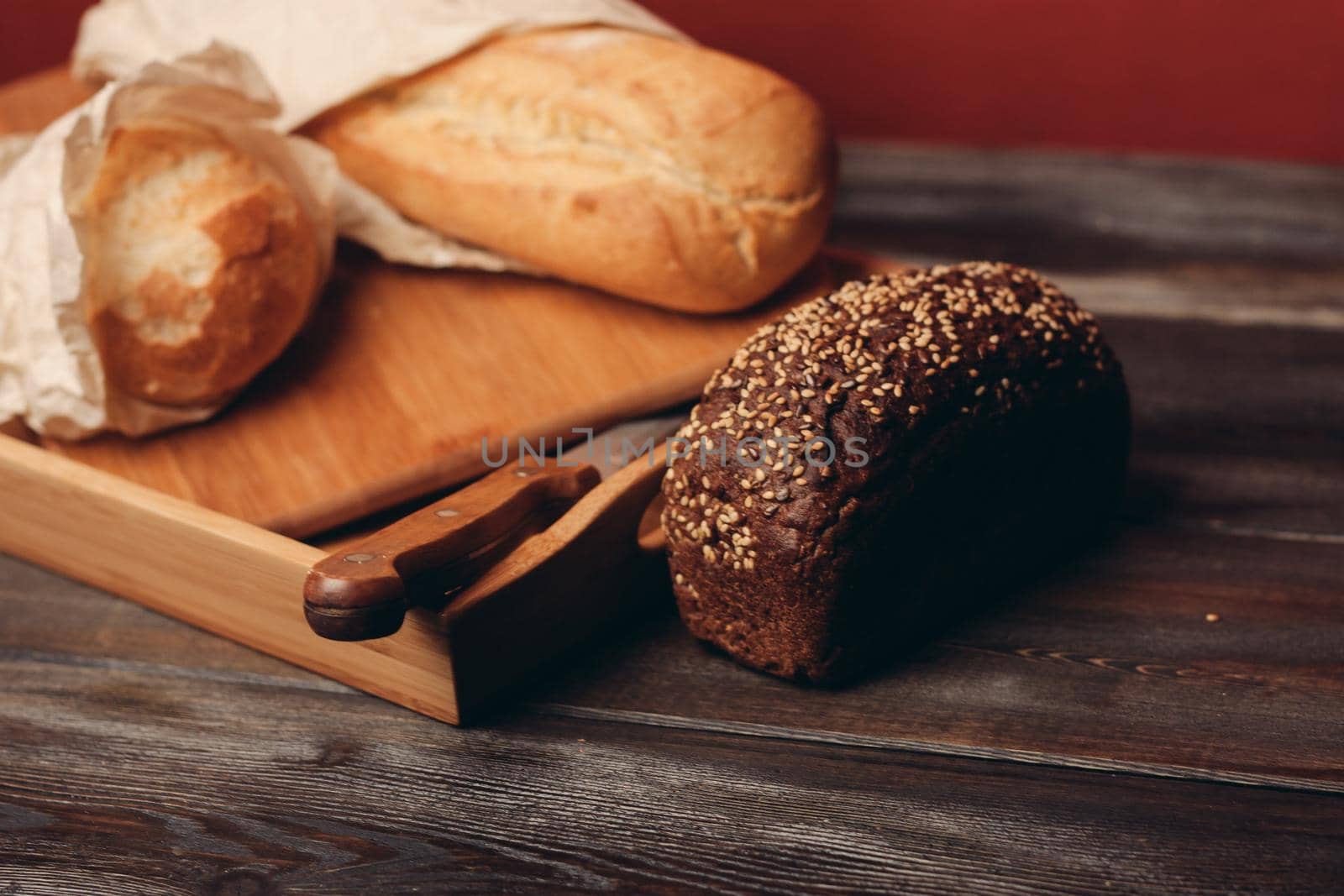 flour products rye bread on a tray and a sharp knife on the table. High quality photo