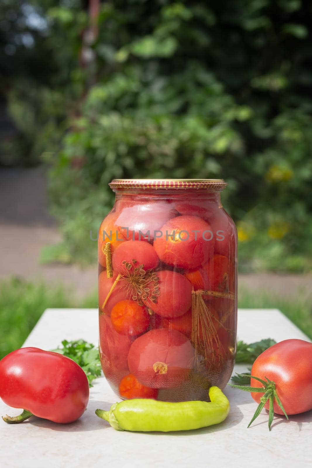Canned tomatoes in a large glass jar. by georgina198
