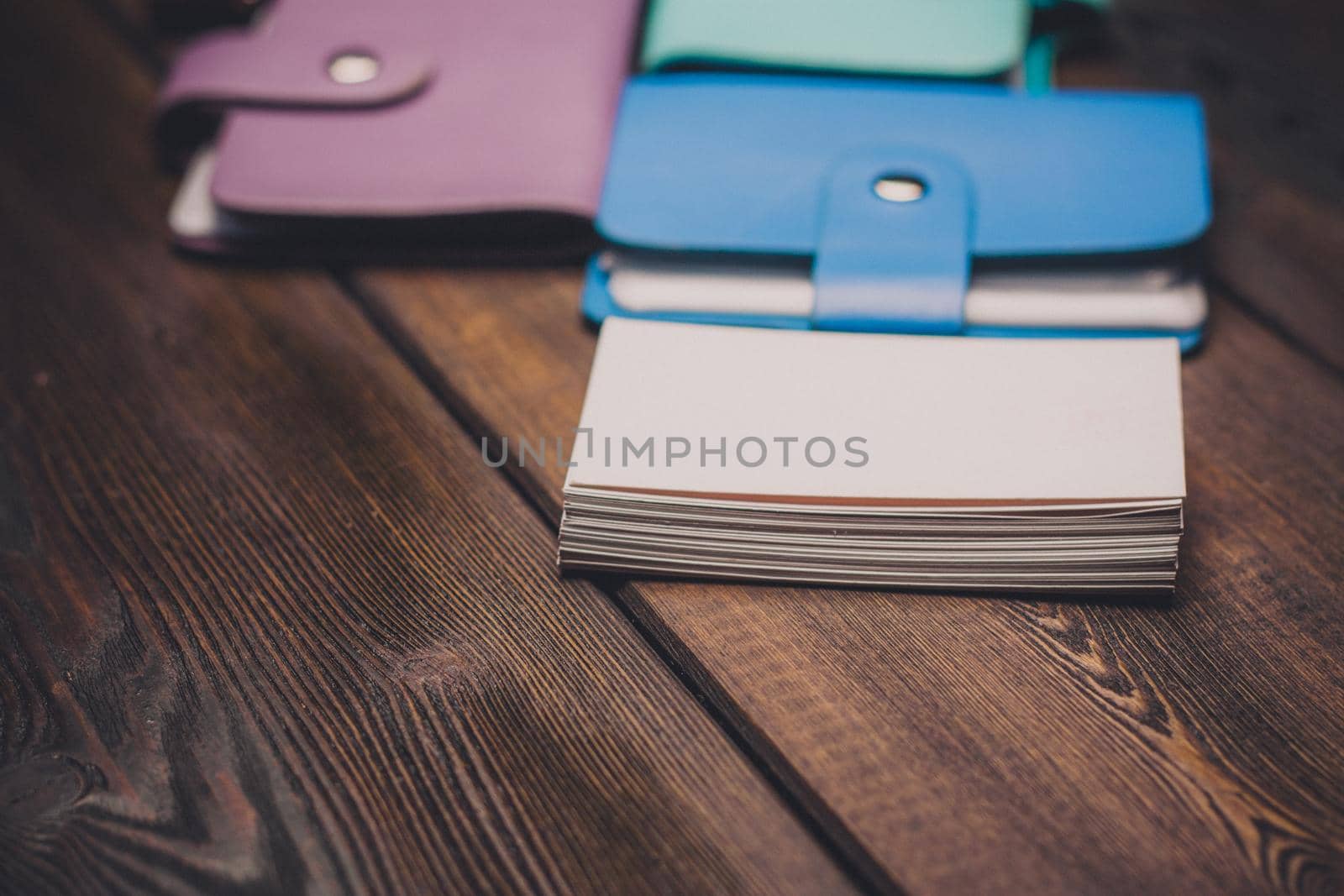bright business card holders on a wooden background texture of a pack of white paper by SHOTPRIME