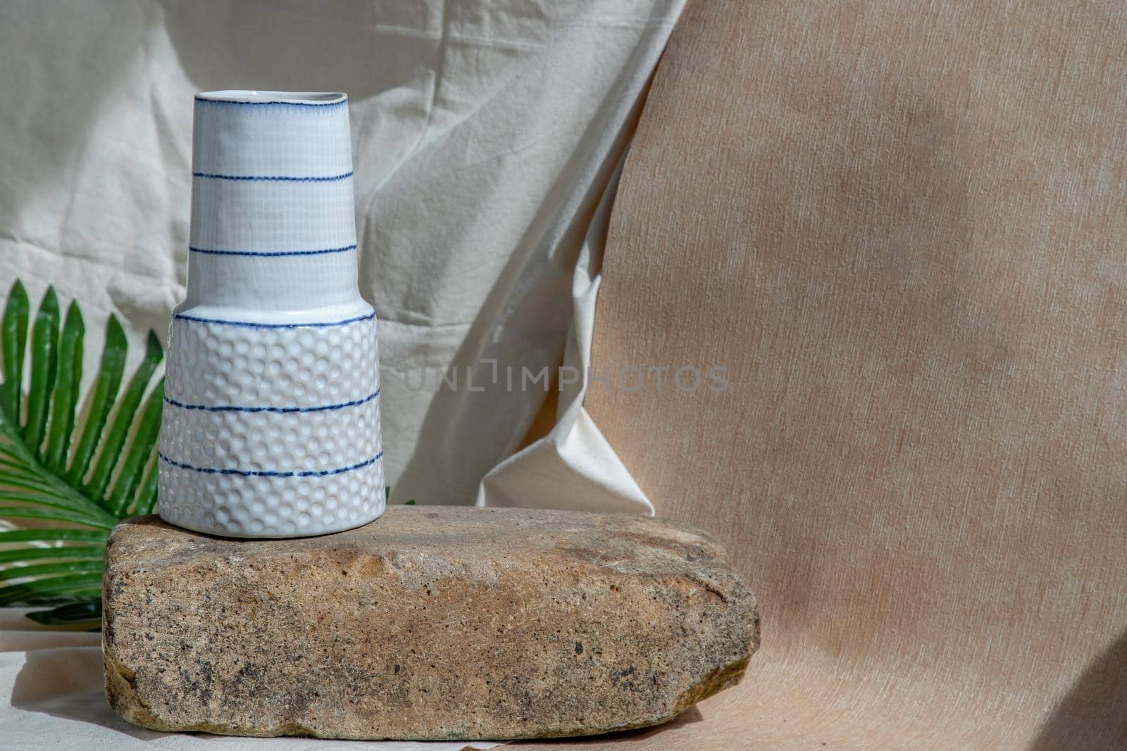 White handmade ceramic vase on Stone. Home decor, Copy space, Selective focus.