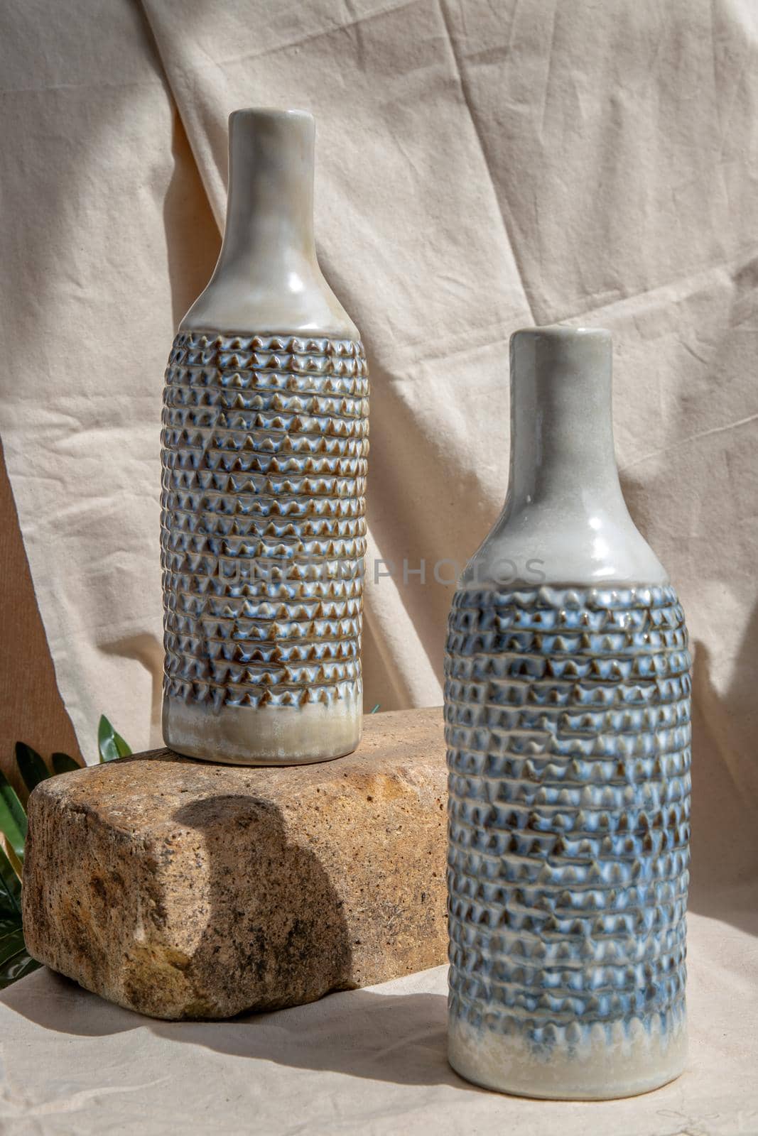 Two white and blue handmade ceramic vases on white textured table cloth.  Home decor, Copy space, Selective focus.