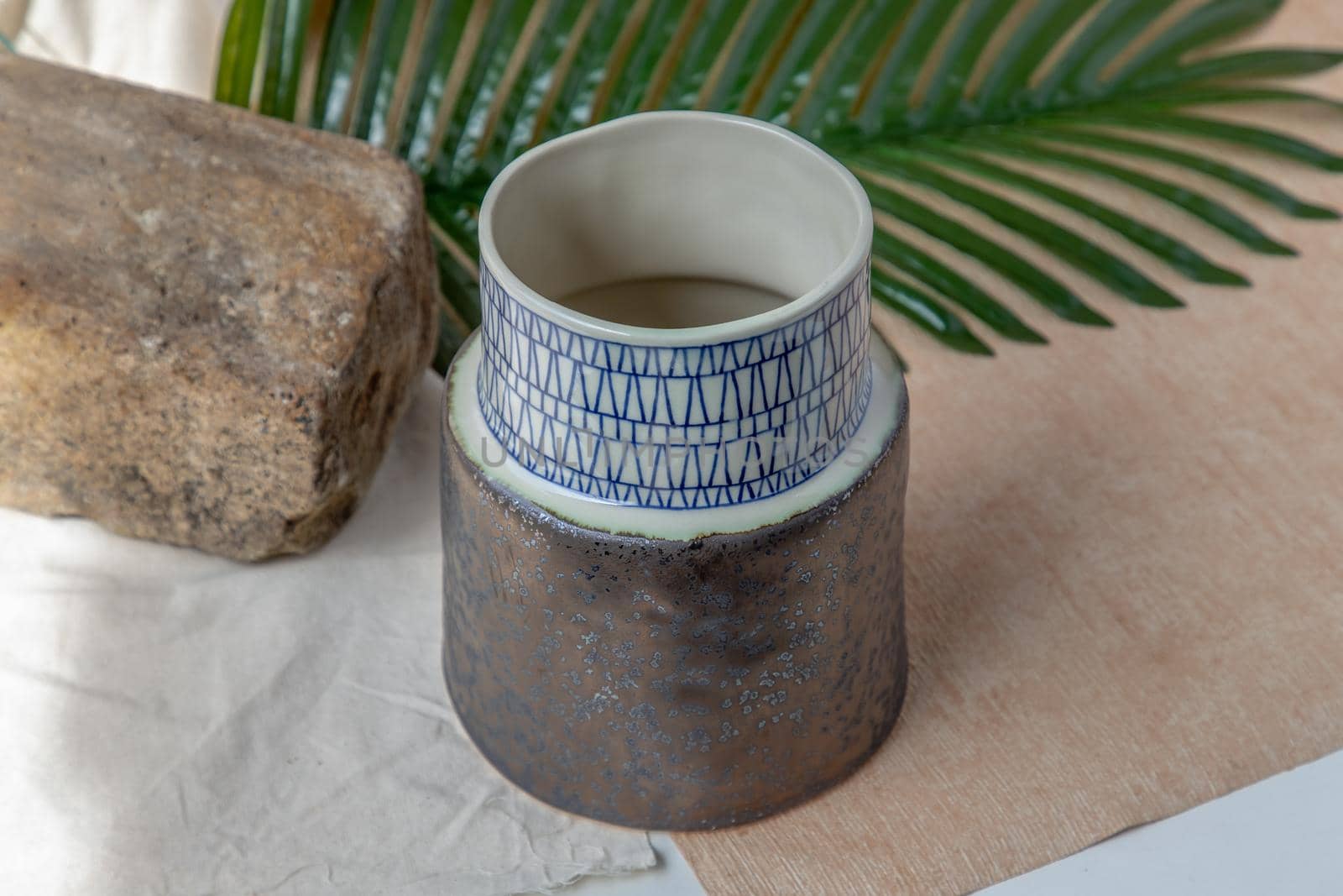 Handmade ceramic vase on white textured table cloth. Home decor, Copy space, Selective focus.