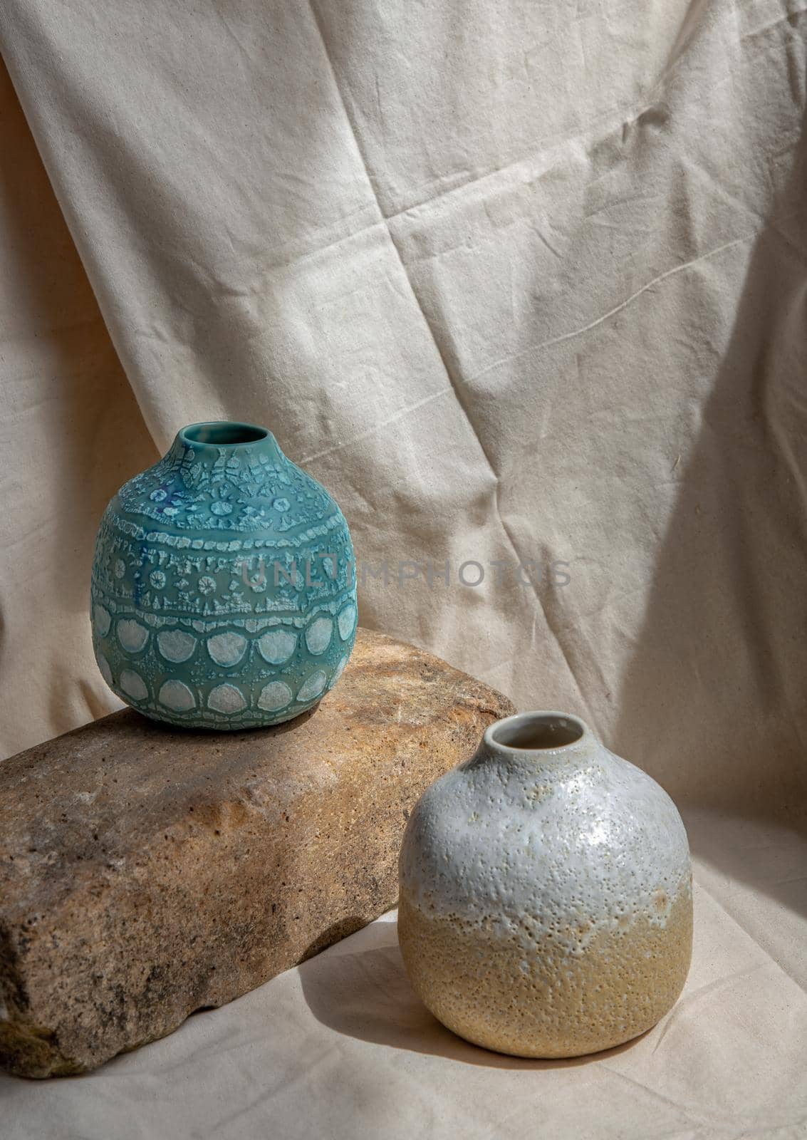 Two handmade ceramic vases on white textured table cloth. Home decor, Copy space, Selective focus.