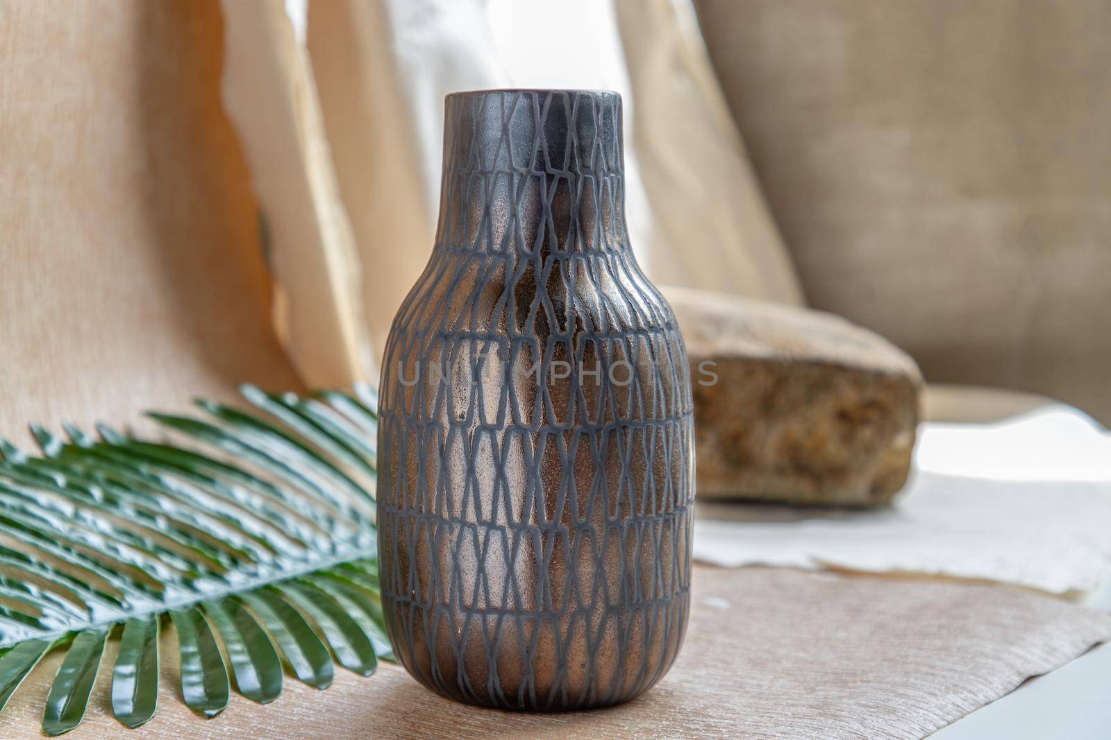 Copper color handmade ceramic vase on white textured table cloth. Home decor, Copy space, Selective focus.
