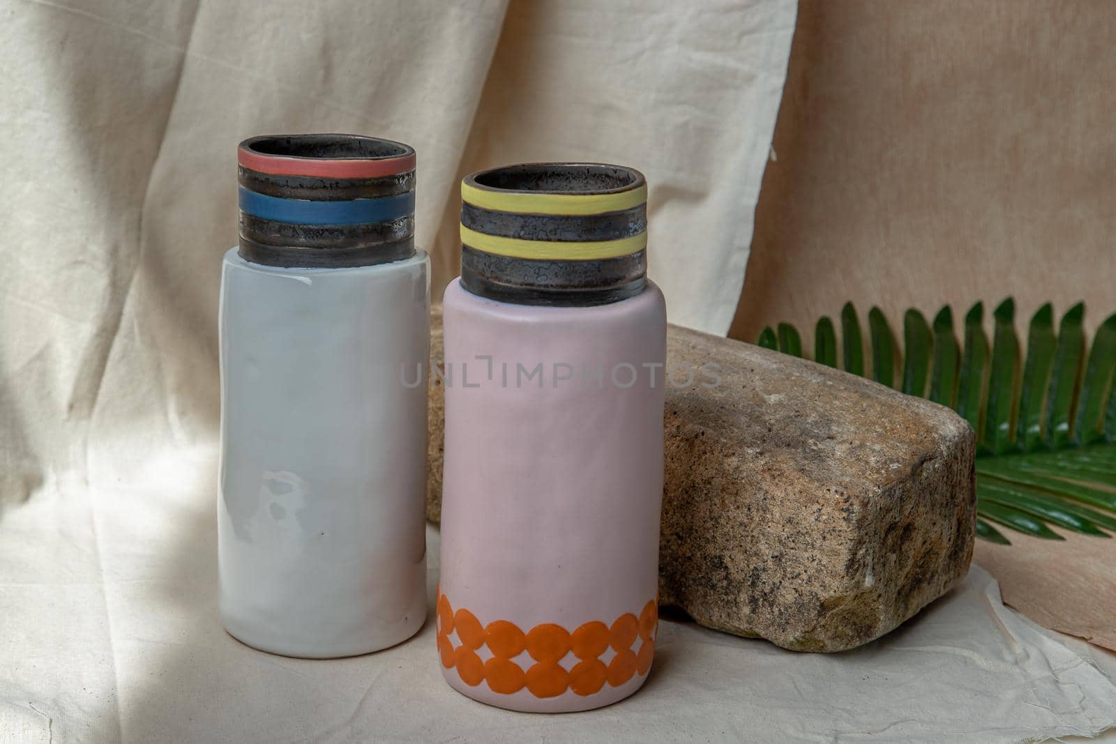 Two Pink and White handmade ceramic vases on white textured table cloth. Home decor, Copy space, Selective focus.